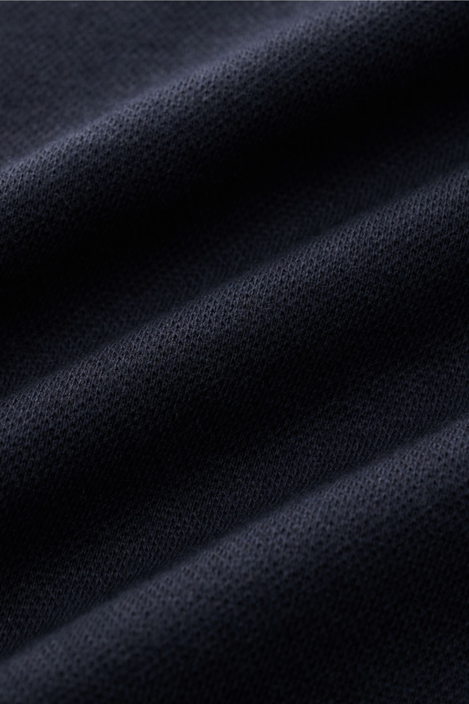 Close-up front view of dark navy fabric texture of 04651/ A trip in a bag Longsleeve-Poloshirt made from soft cotton-cashmere piqué jersey.

Dieses Longsleeve-Poloshirt von 04651/ A TRIP IN A BAG aus softem Piqué-Jersey wurde aus einem edlen Baumwoll-C