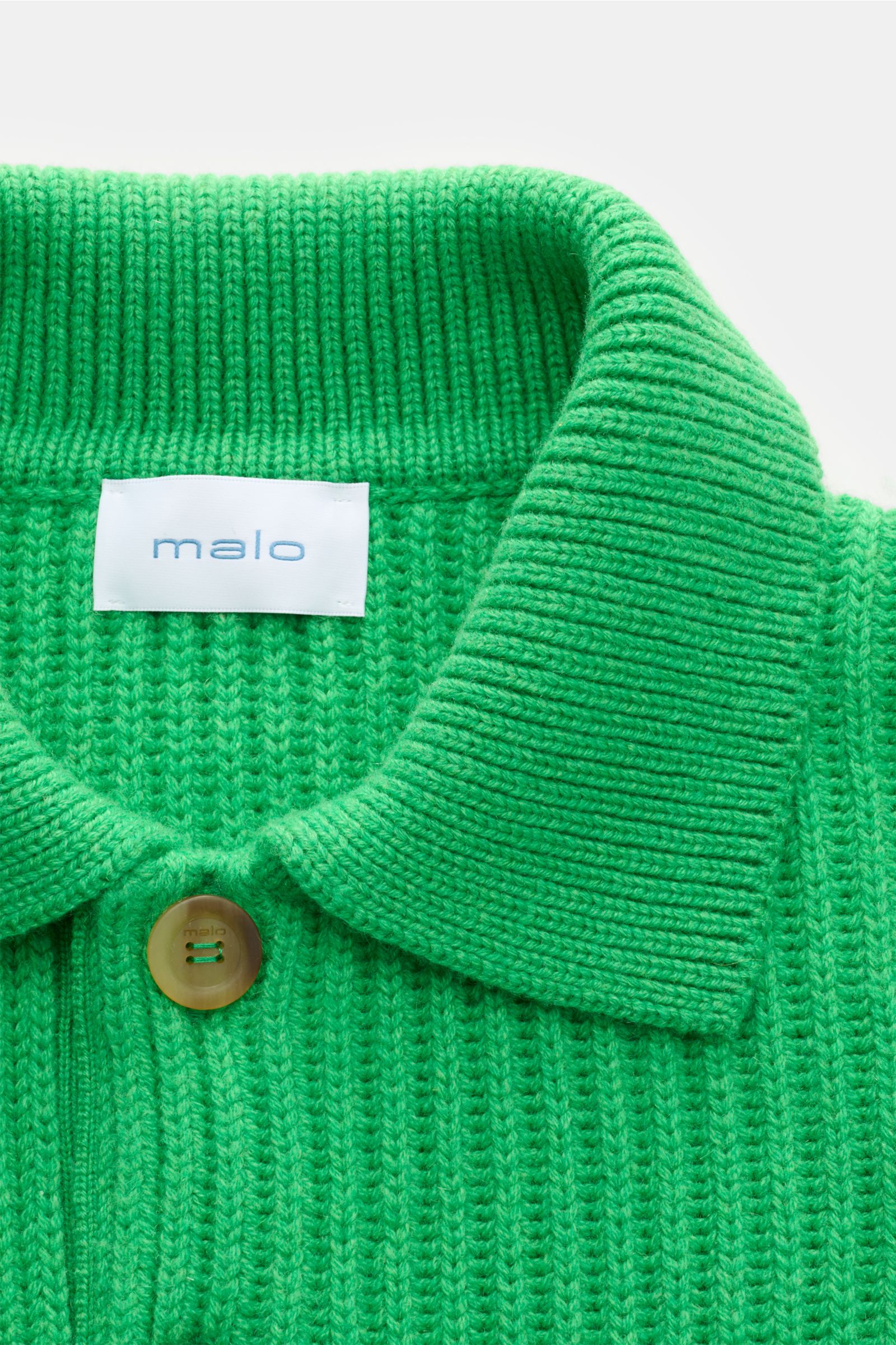 Malo Cashmere Strickpolo grün aus reiner Cashmere, Detailaufnahme von oben zeigt weichen Griff, schwere Qualität, Patent-Strickmuster, Oversized Fit, Drei-Knopf-Leiste, typischen Polokragen und elastische Rippbündchen.