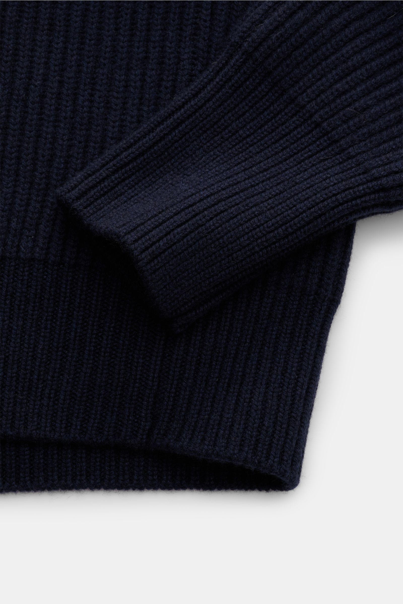 Nahaufnahme des Ärmels und Saums eines Malo Cashmere Strickpolo navy aus grobem italienischem Strick mit Patentmuster, elastischem Rippbündchen, Oversized Fit und sehr weichem Griff aus reiner Cashmere, fotografiert von schräg oben.