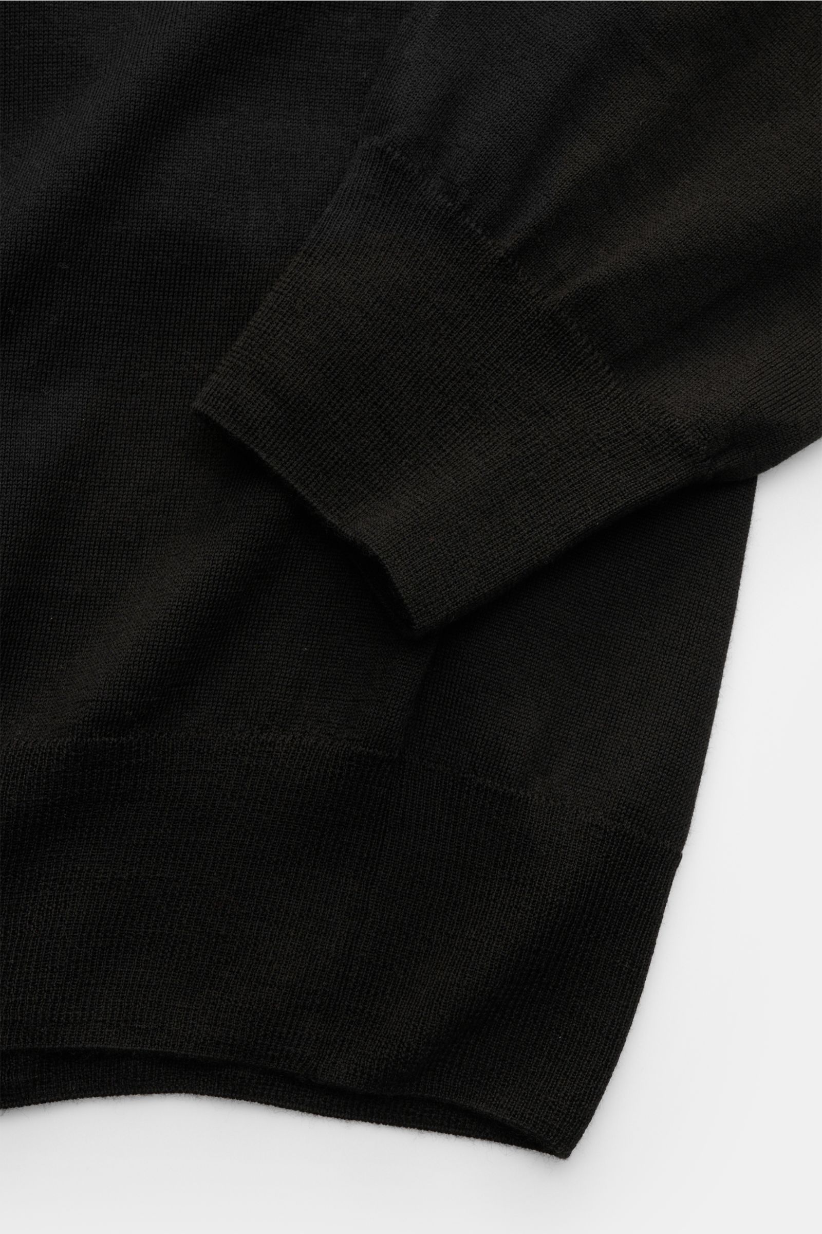 Moorer Strickpolo 'Alonso' schwarz aus feinstem Woll-Feinstrick mit Polokragen, glatter Knopfleiste und engen Rippbündchen, Detailaufnahme.