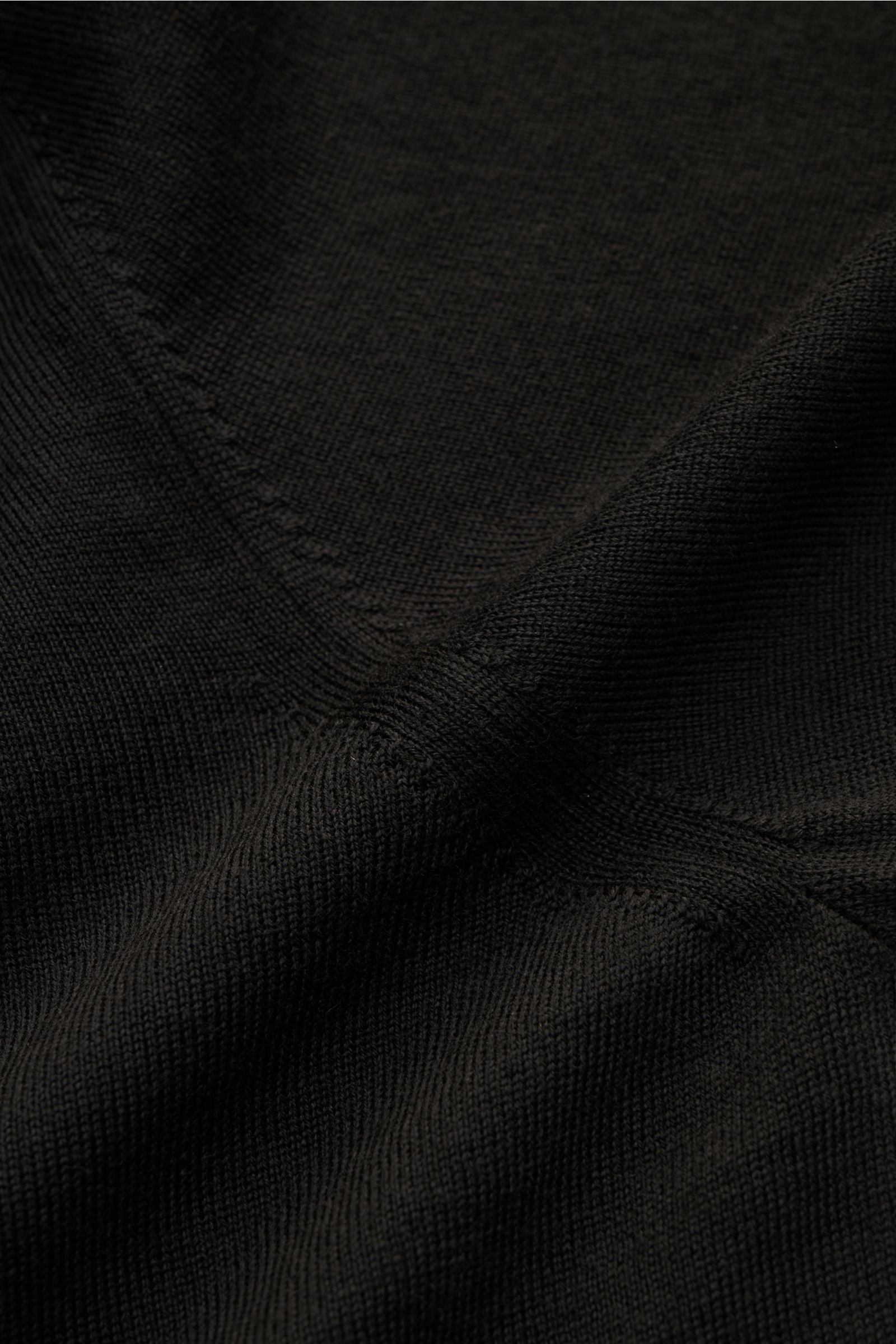 Nahaufnahme des feinen Strickbilds des Moorer Strickpolo 'Alonso' schwarz aus reiner Wolle mit weichem Griff, Polokragen und Rippbündchen.