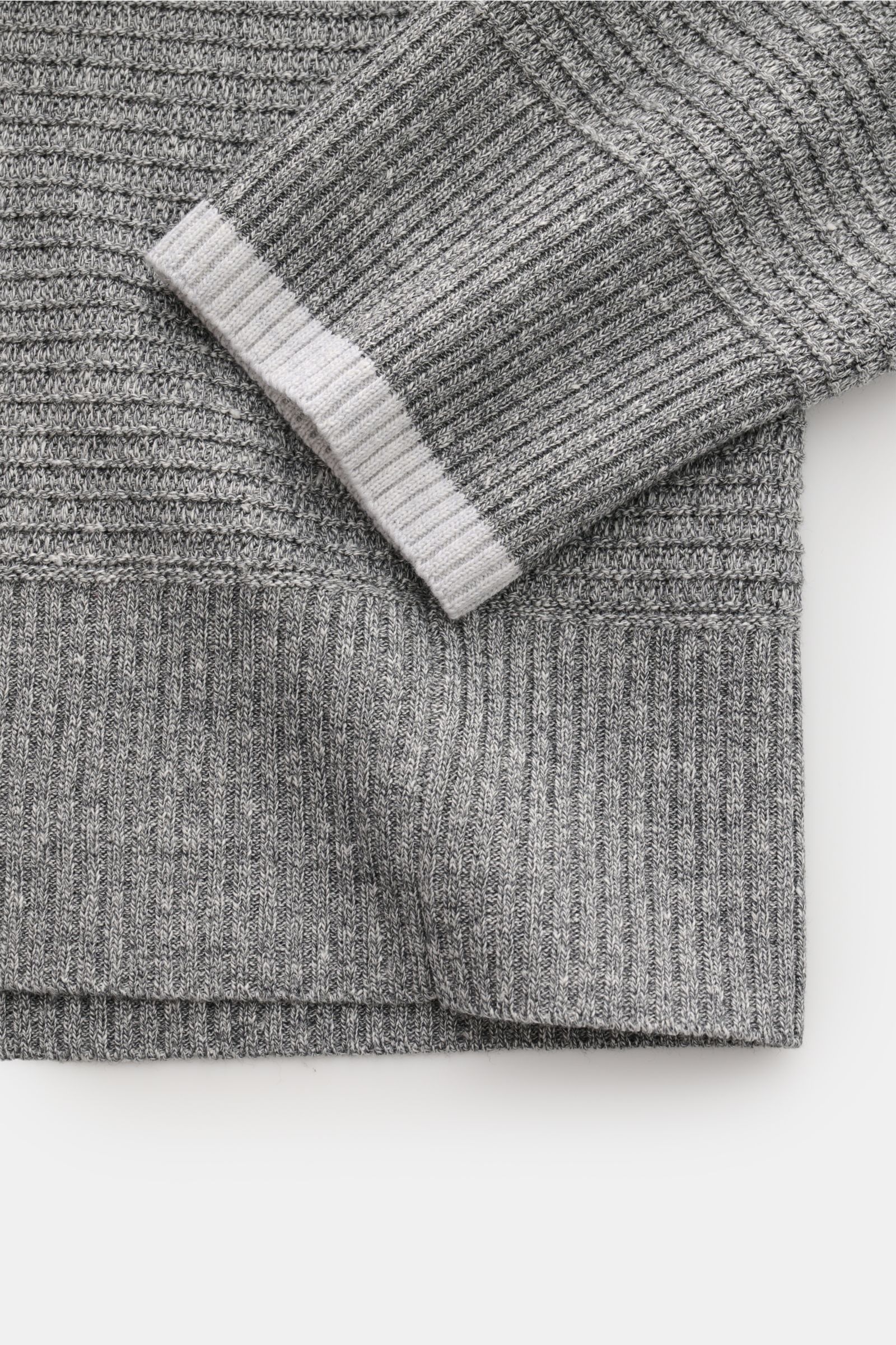 Close-up view of Thom Browne Strickpolo grau meliert showing grey melange knit texture, ribbed hem and sleeve with white contrast cuff, highlighting structure and fabric detail. Versatile style favorite: The knit polo by U.S. designer THOM BROWNE combines