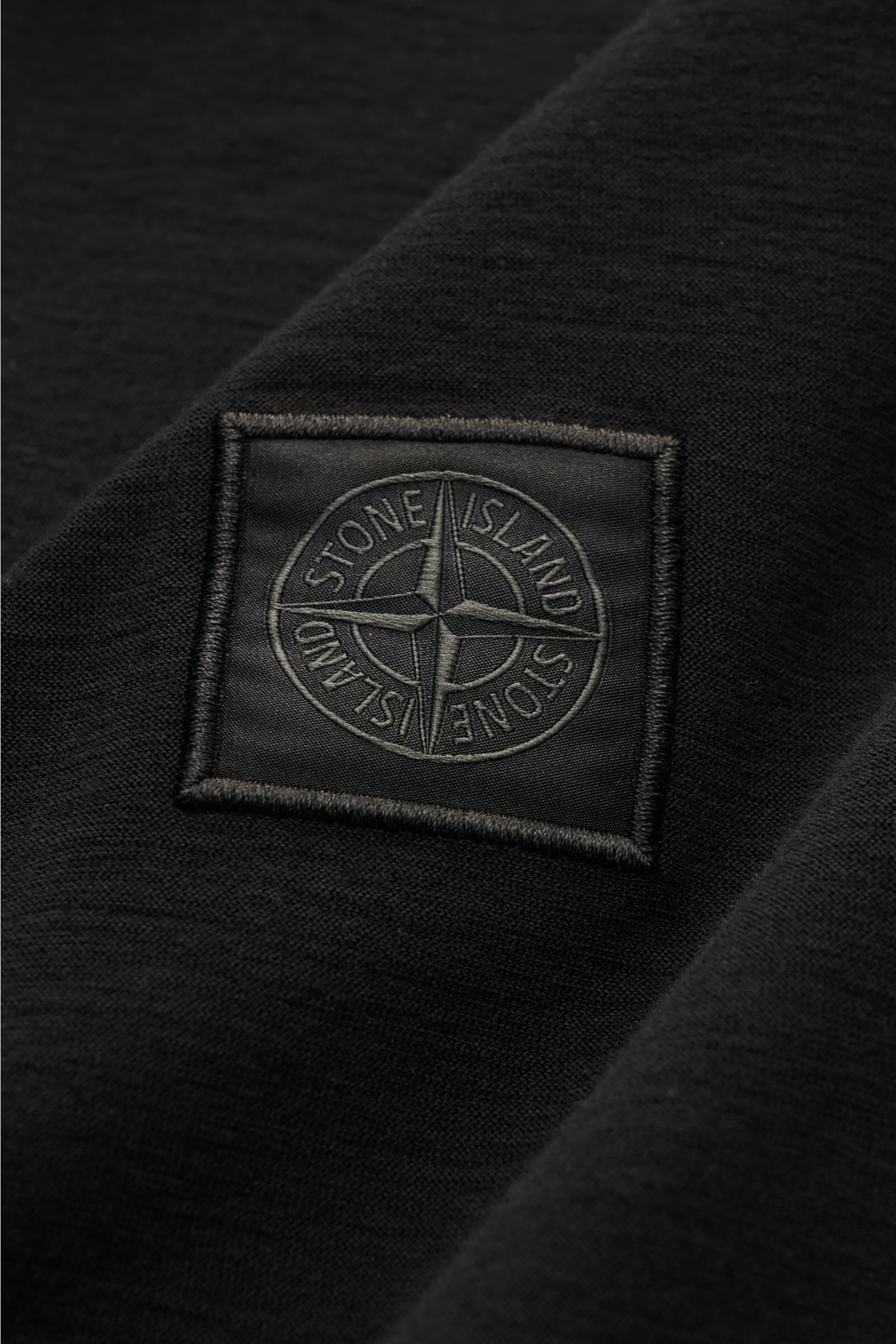 Stone Island Longsleeve-Poloshirt 'Ghost Piece' schwarz in Nahaufnahme, monochromes, garment dyed Jersey mit tonalem Kompasslogo.