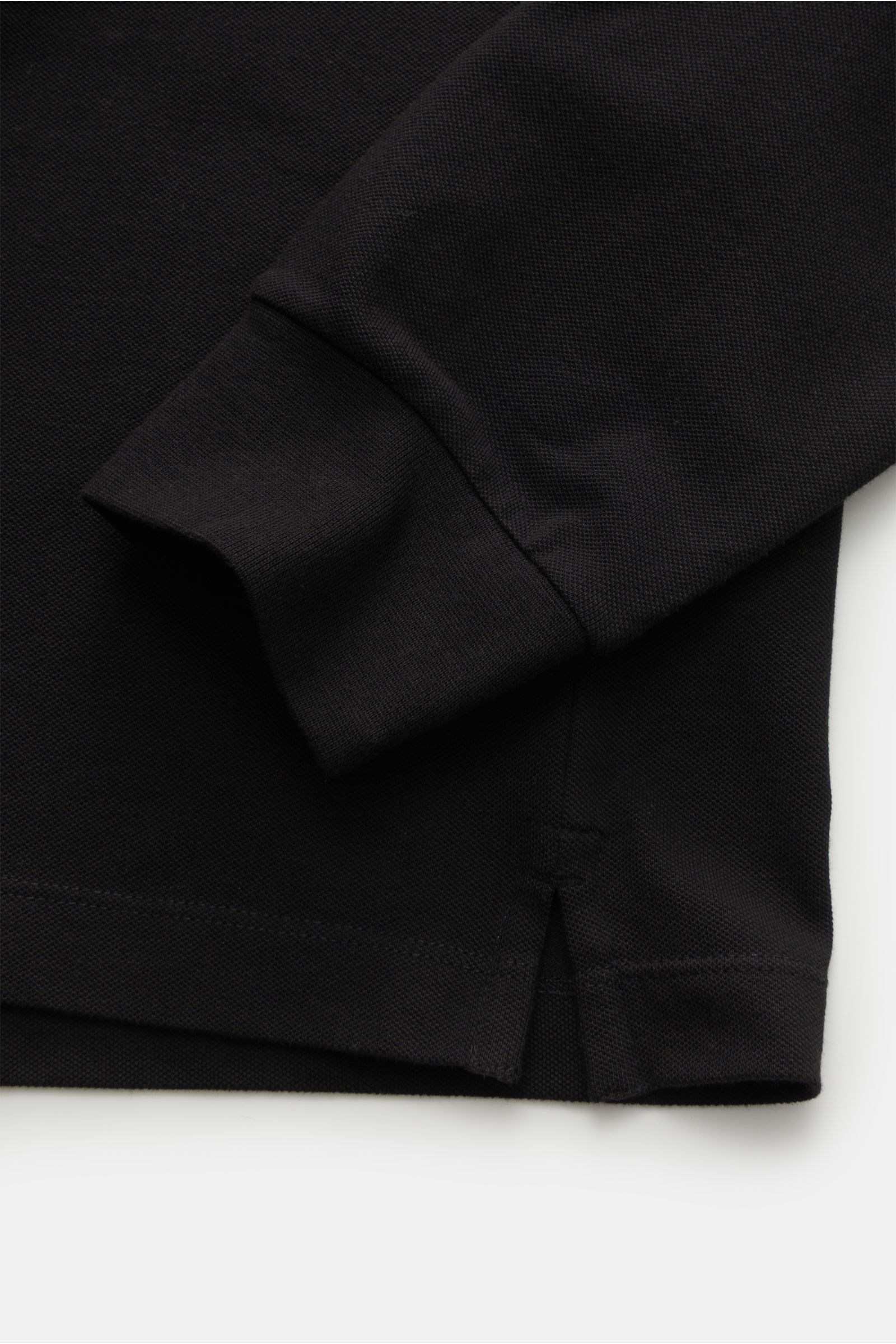 Stone Island Longsleeve-Poloshirt schwarz, Detailaufnahme von Arm und Saum mit Seitenschlitz, Piqué-Baumwolle, Slim Fit, tonales Kompasslogo.