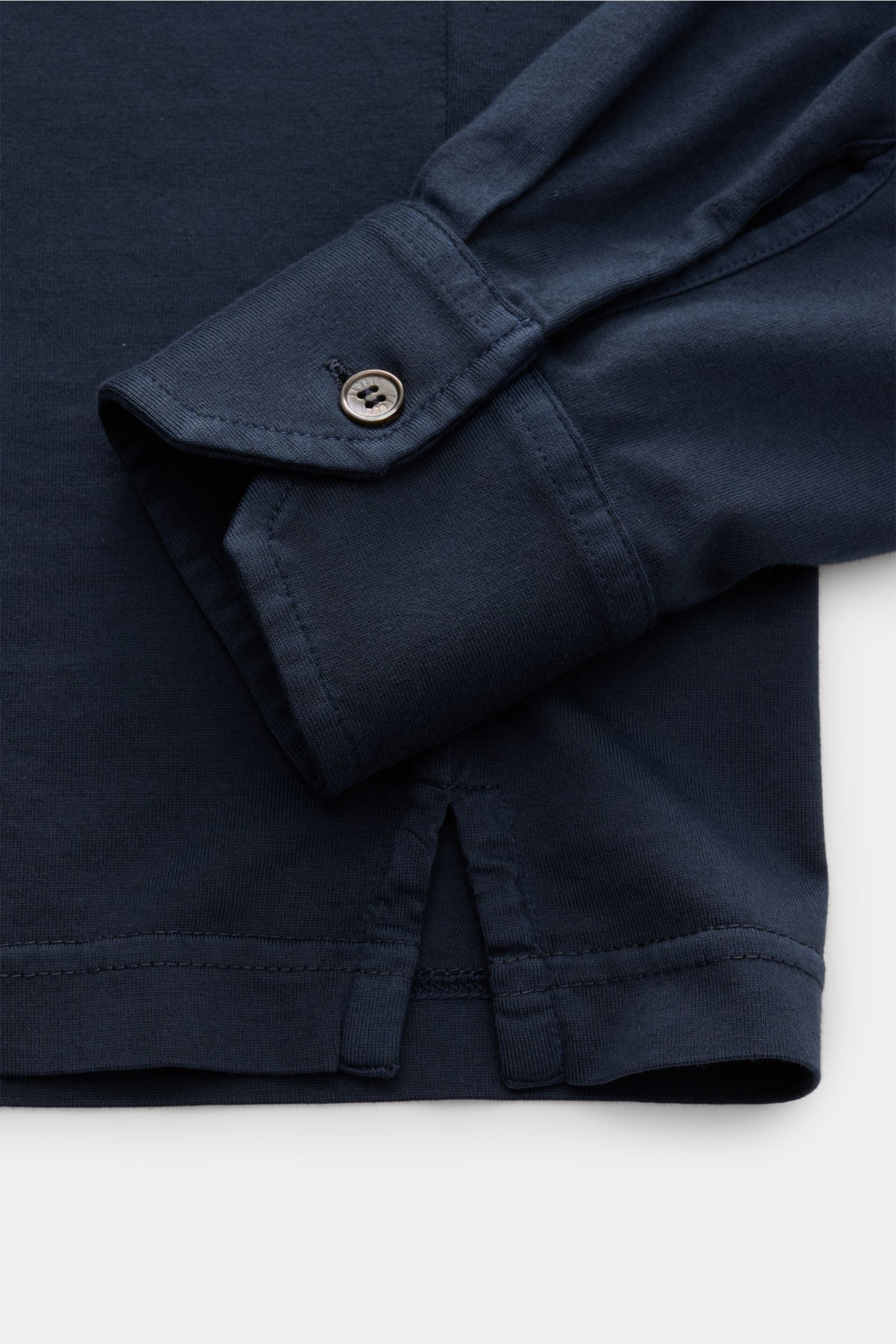 Nahaufnahme des Fedeli Jersey Longsleeve-Poloshirts 'Zero' navy von unten, Detail des Seitenschlitzes, klassischer Sportmanschette mit Perlmuttknopf, aus glattem, seidigem, nachhaltigem Giza-Baumwoll-Jersey in Slim Fit, garment dyed.