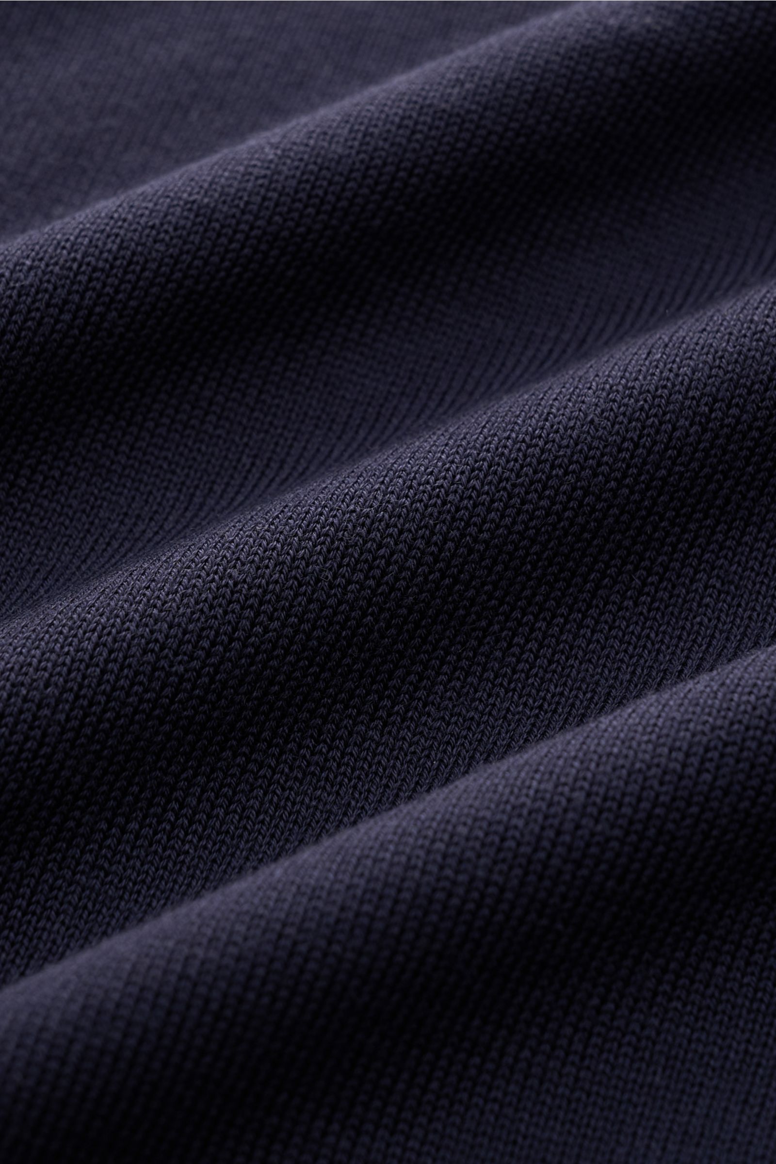 Close-up des feinen Strickbilds vom Officine Générale Strickpolo 'Simone' navy aus Lyocell-Wolle, weicher Griff sichtbar.
