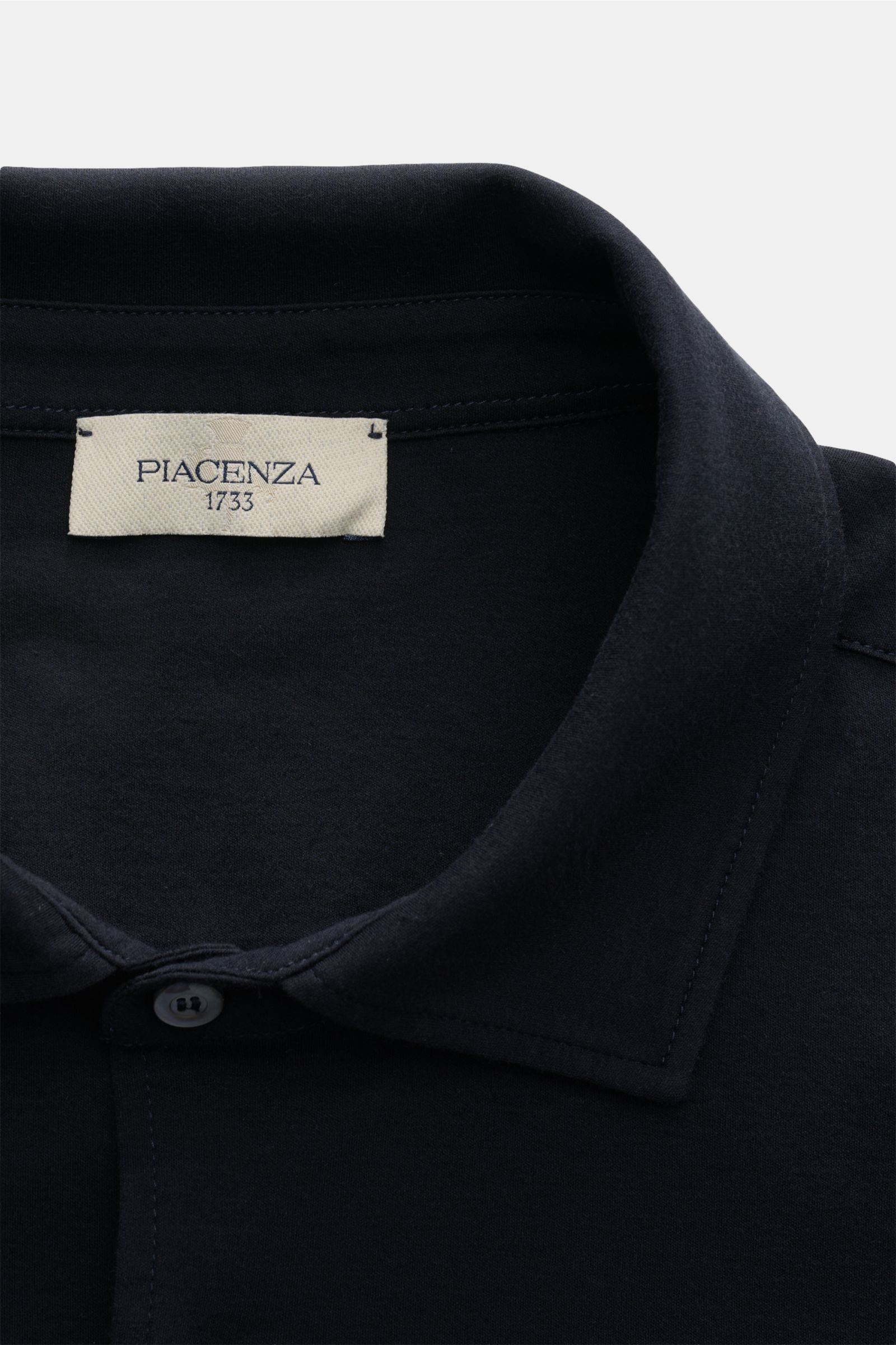 Nahaufnahme aus leichter Vogelperspektive des Piacenza 1733 Jersey-Hemd schmaler Kragen dark navy mit weichem Jersey, klassischer Sportmanschette, Slim Fit, glatter Knopfleiste.