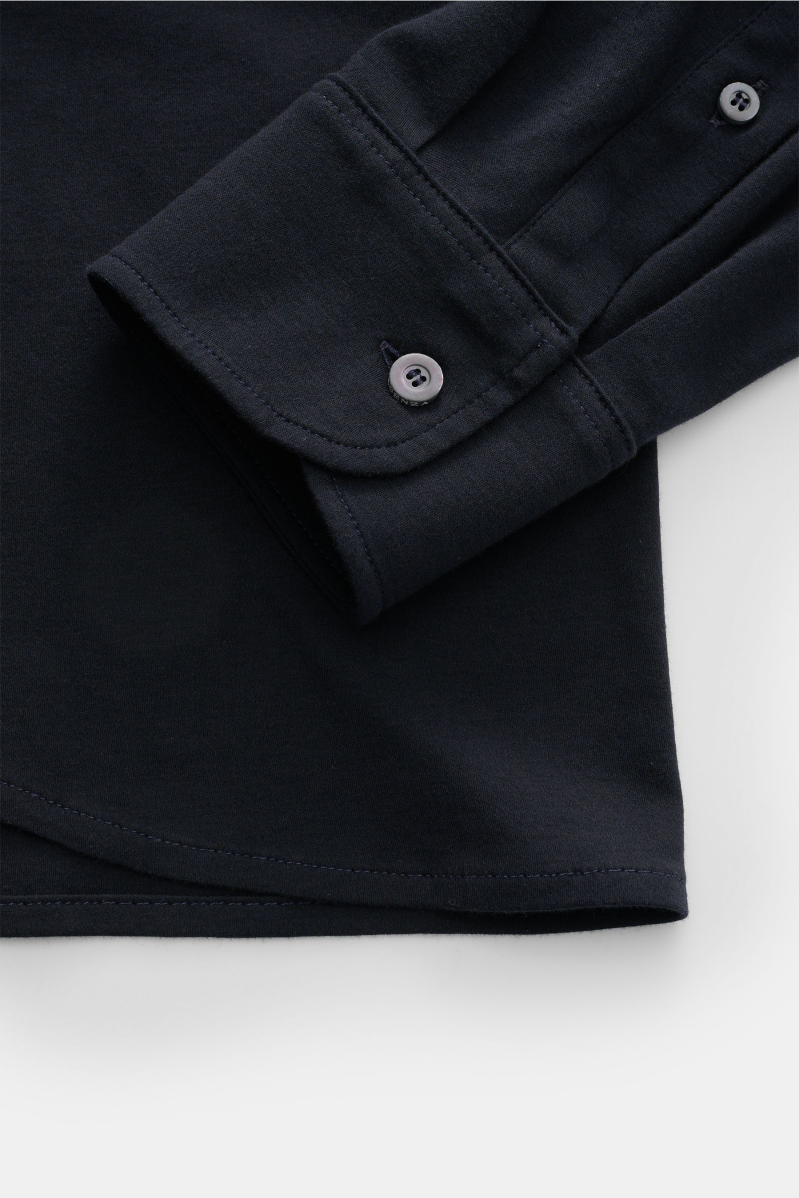 Piacenza 1733 Jersey-Hemd schmaler Kragen dark navy, Detailaufnahme der klassischen Sportmanschette aus weichem Baumwolljersey, Slim Fit, glatte Knopfleiste, feines Strickbild, Perspektive seitlich nah.