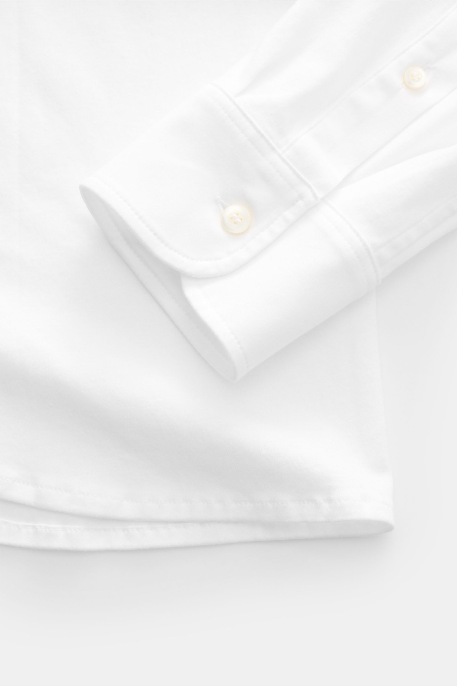 Close-up of the cuff and button placket of the Piacenza 1733 Jersey shirt slim collar white, photographed from above showing fine knit and classic barrel cuffs.

Luxurious comfort for everyday wear: This jersey shirt from PIACENZA 1733, made from soft 
