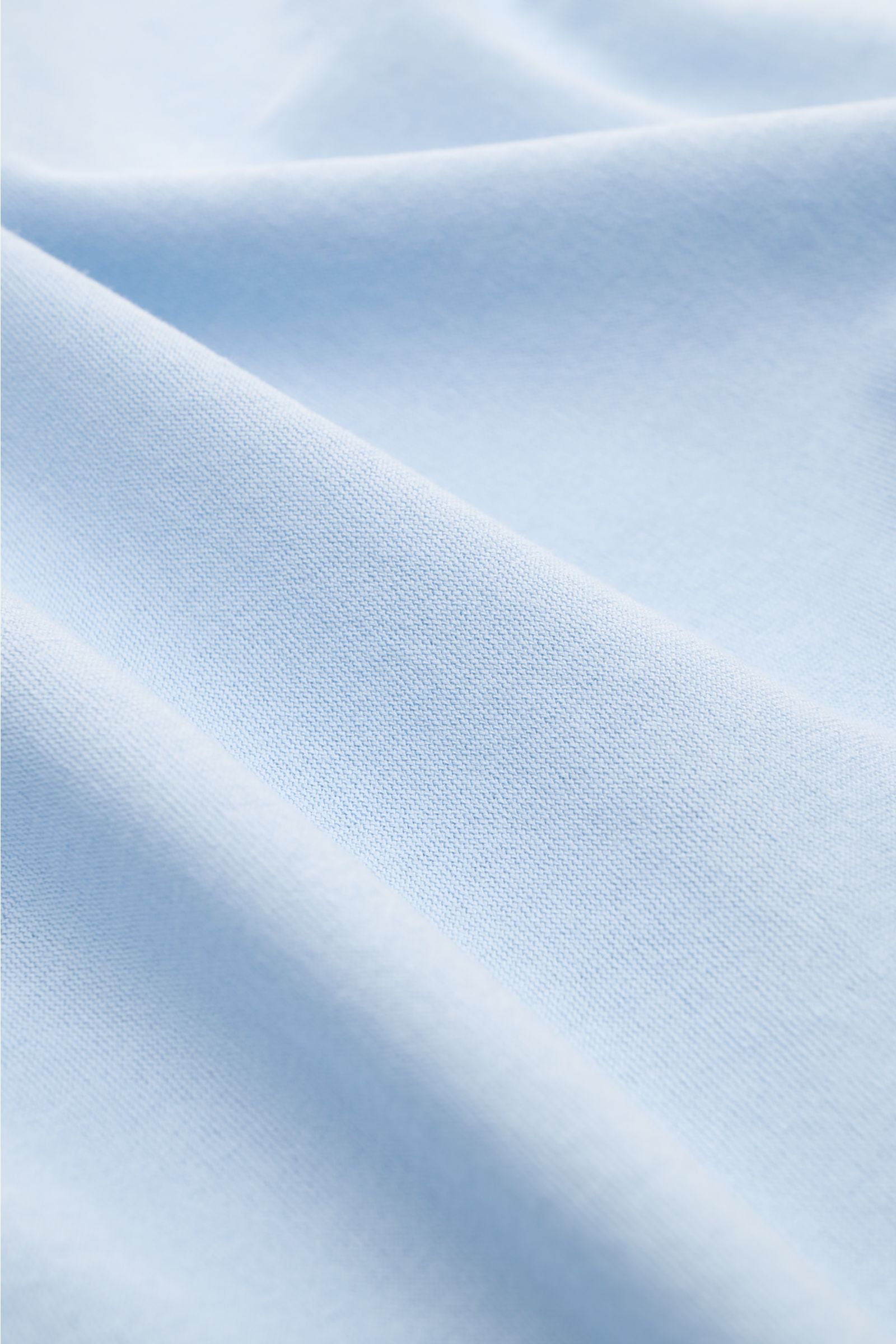 Close-up front view of light blue Gran Sasso Jersey Longsleeve-Poloshirt hellblau fabric showing soft cotton jersey, slim fit, shark collar, smooth three-button placket, classic sport cuffs, and side hem slits, sporty and comfortable for everyday wear.