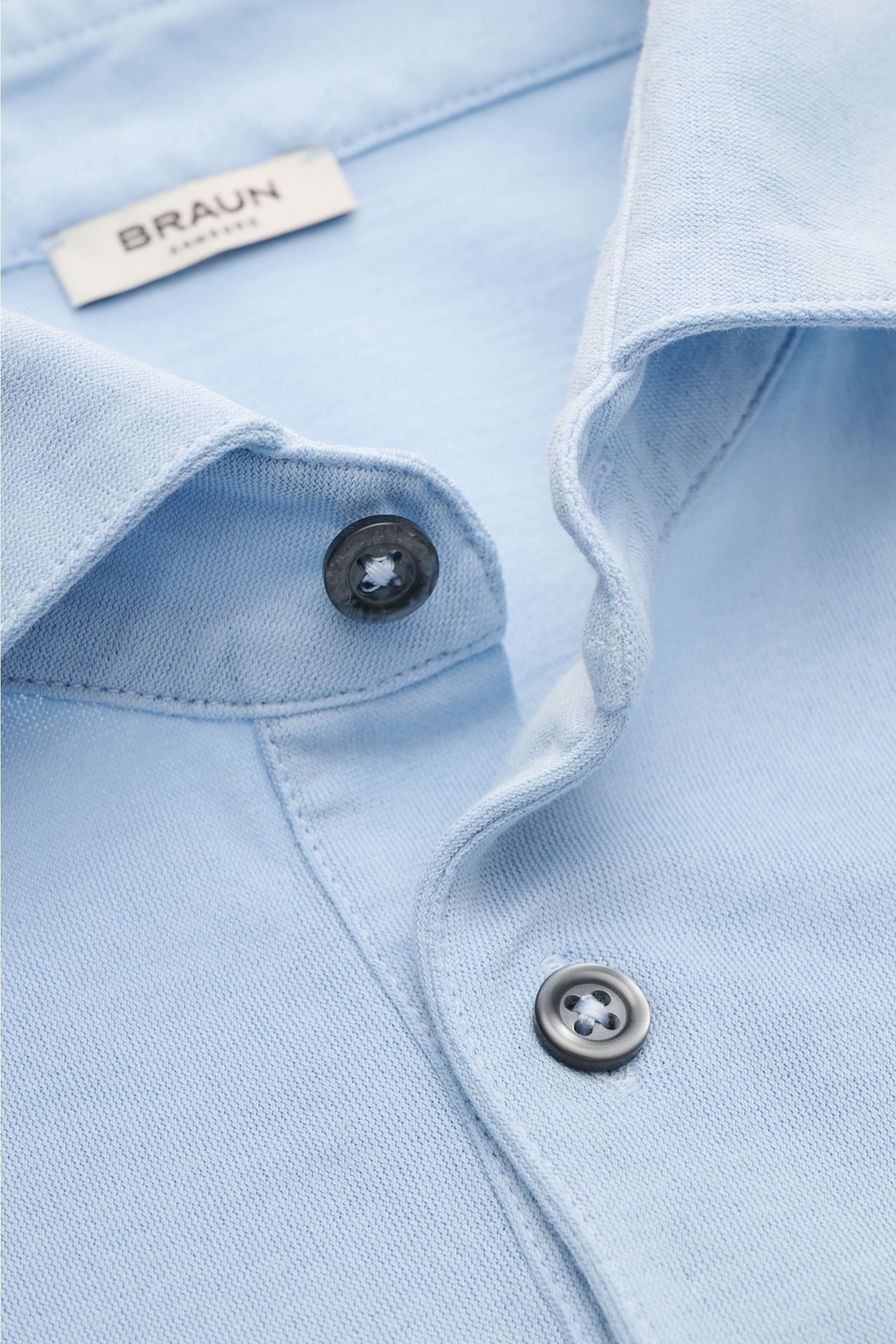 Gran Sasso Jersey Longsleeve-Poloshirt hellblau close-up from above showing light blue cotton jersey fabric, shark collar, smooth three-button placket, and stitching details. Sportiv in die neue Saison: BRAUN HAMBURG verarbeitet reine Baumwolle zu komf