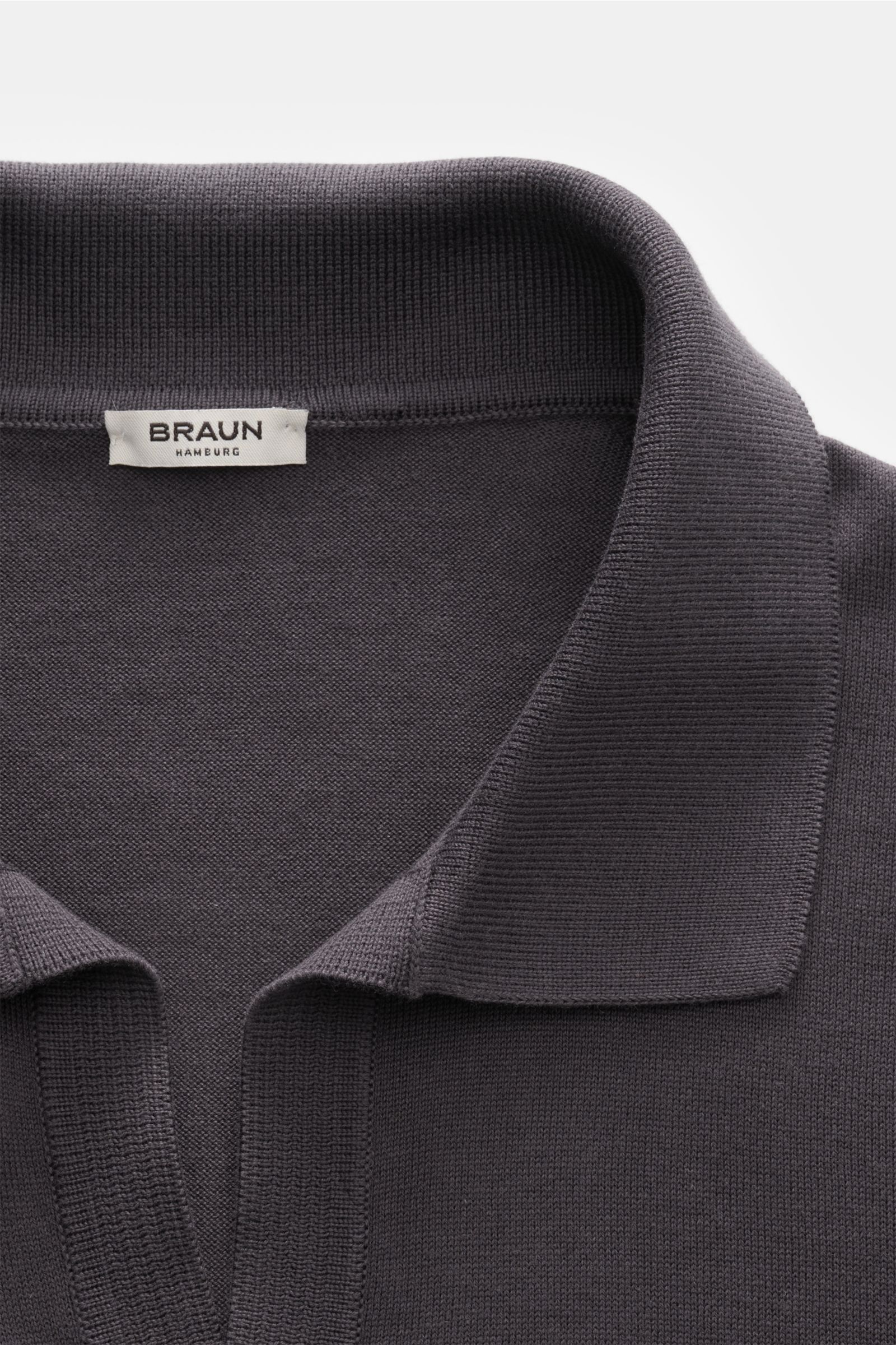 Nahaufnahme des BRAUN Hamburg Strickpolo anthrazit aus leichter Baumwolle mit offenem Polokragen und feinem Strickbild, von oben fotografiert.