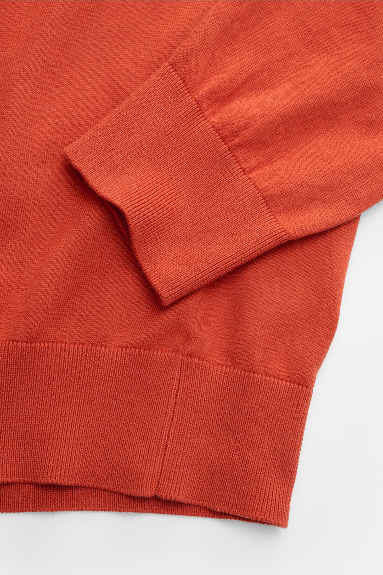 Gran Sasso Strickpolo orange aus reiner Baumwolle in feinem Strick, Detailaufnahme von Ärmel und Bund mit elastischen Rippbündchen.