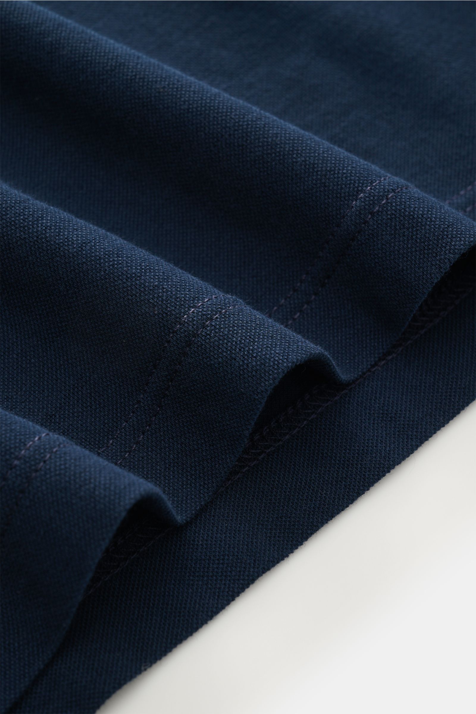 Nahaufnahme des navyfarbenen BRAUN Hamburg Longsleeve-Poloshirts aus hochwertigem Baumwoll-Piqué mit weichem Griff und feiner Naht, fotografiert von oben.