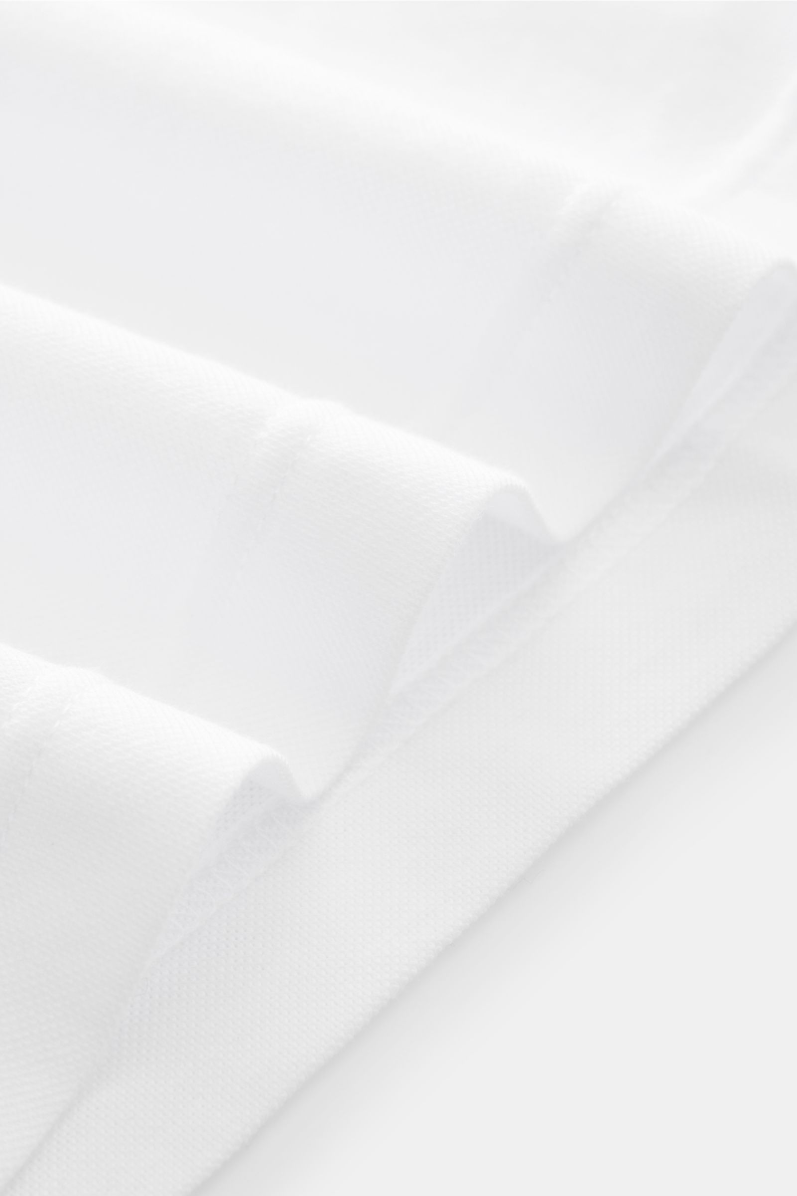 BRAUN Hamburg Longsleeve-Poloshirt weiß, sportiv und stilvoll, Slim Fit, Baumwoll-Piqué, Haifisch-Kragen, Fünf-Knopf-Leiste, von schräg oben fotografiert.