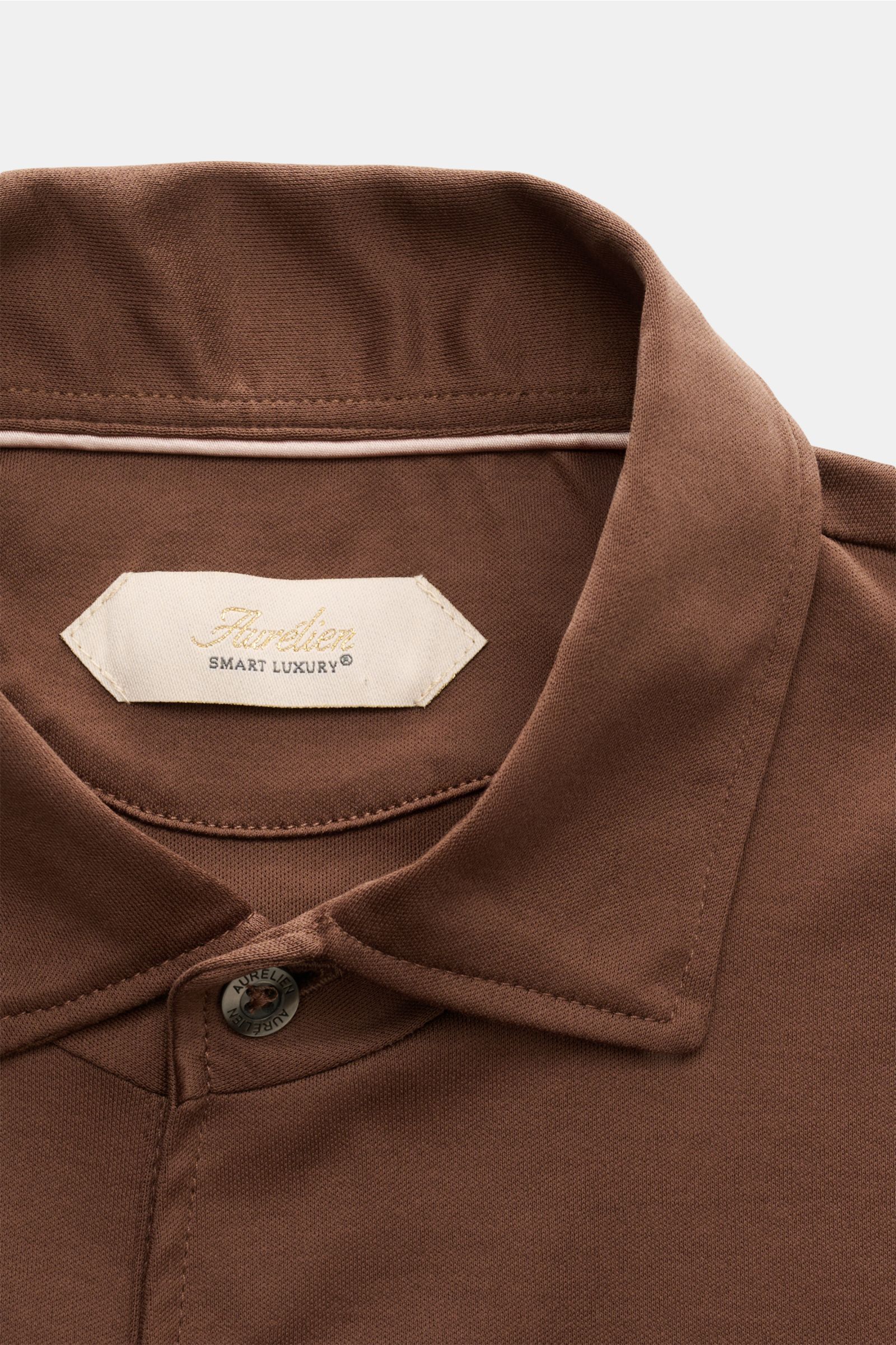 Close-up front view of the Aurélien Jersey Longsleeve-Poloshirt braun collar and top button, made of soft Egyptian cotton jersey.

Das vielseitig einsetzbare Longsleeve-Poloshirt der Marke AURÉLIEN wurde aus edler ägyptischer Baumwolle in feiner Jersey