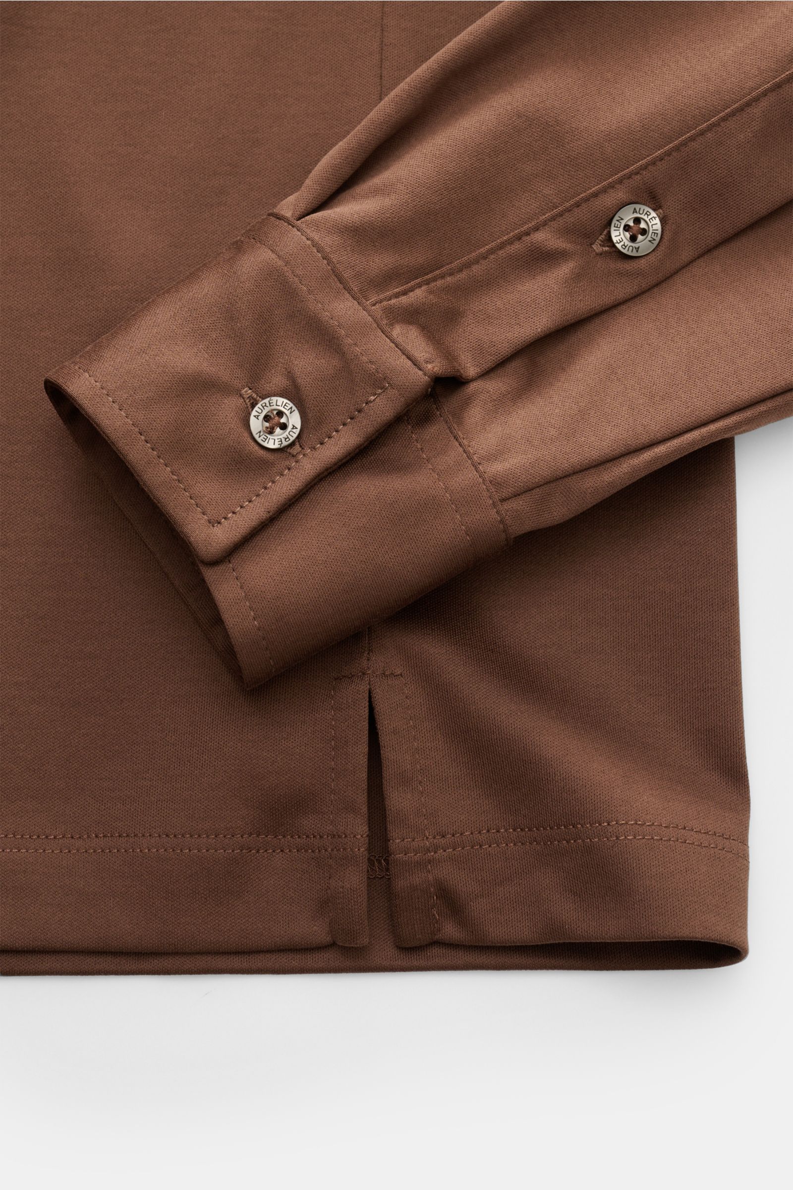 Close-up image from above showing the sleeve cuff and hem with side slit of the brown Aurélien Jersey Longsleeve-Poloshirt braun, made from soft Egyptian cotton jersey. Das vielseitig einsetzbare Longsleeve-Poloshirt der Marke AURÉLIEN wurde aus edler 