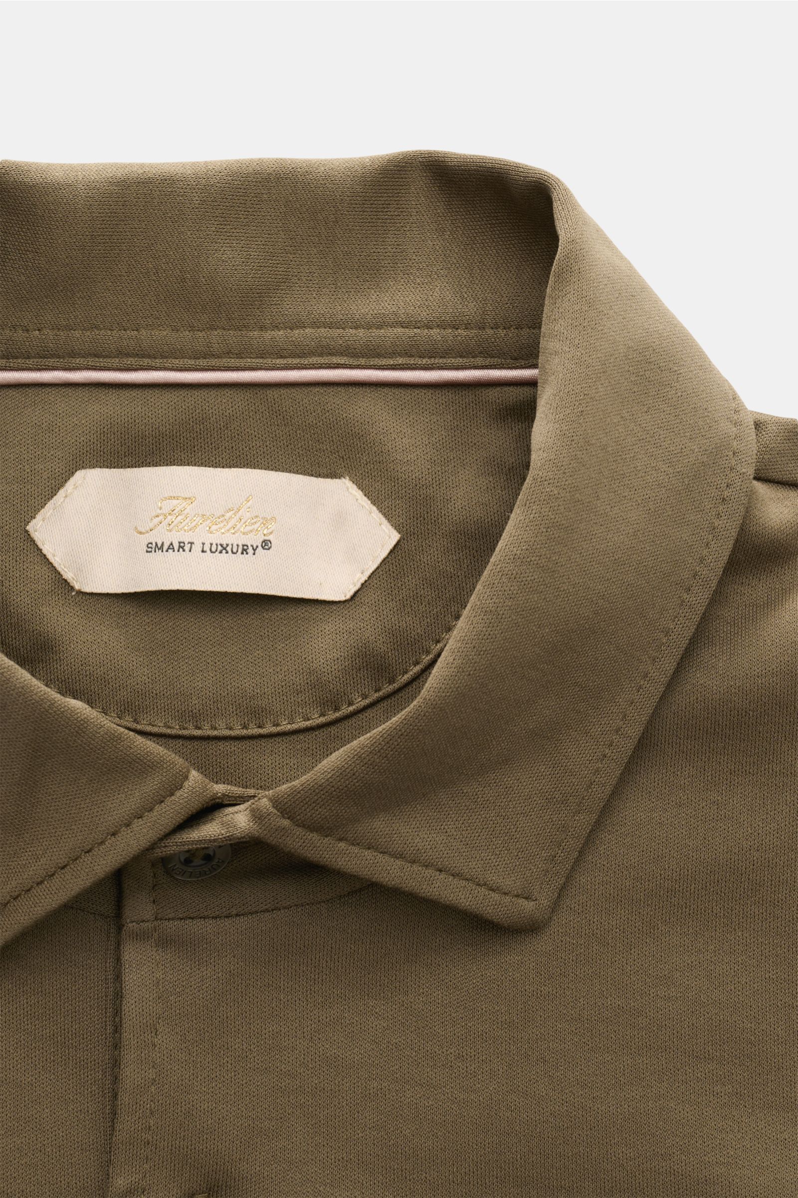 Nahaufnahme des Aurélien Jersey Longsleeve-Poloshirt oliv von oben, zeigt Polokragen, Drei-Knopf-Leiste und feine Jersey-Qualität.
