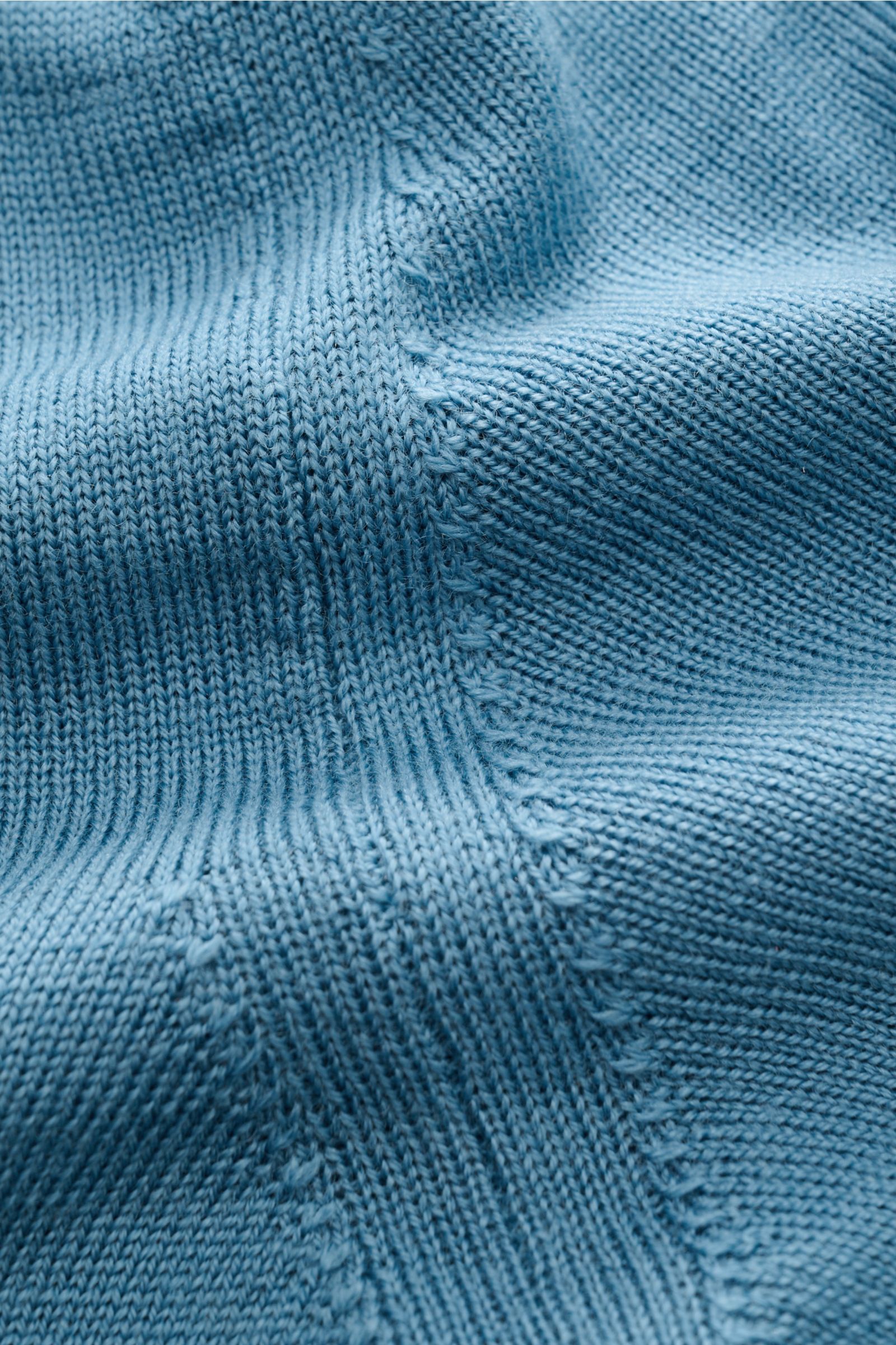 Nahaufnahme des blauen Aurélien Merino Strickpolo, Detail des feinen Merinowoll-Strickbilds mit weichem Griff und Rippbündchen, sportlich-lässiger Look.
