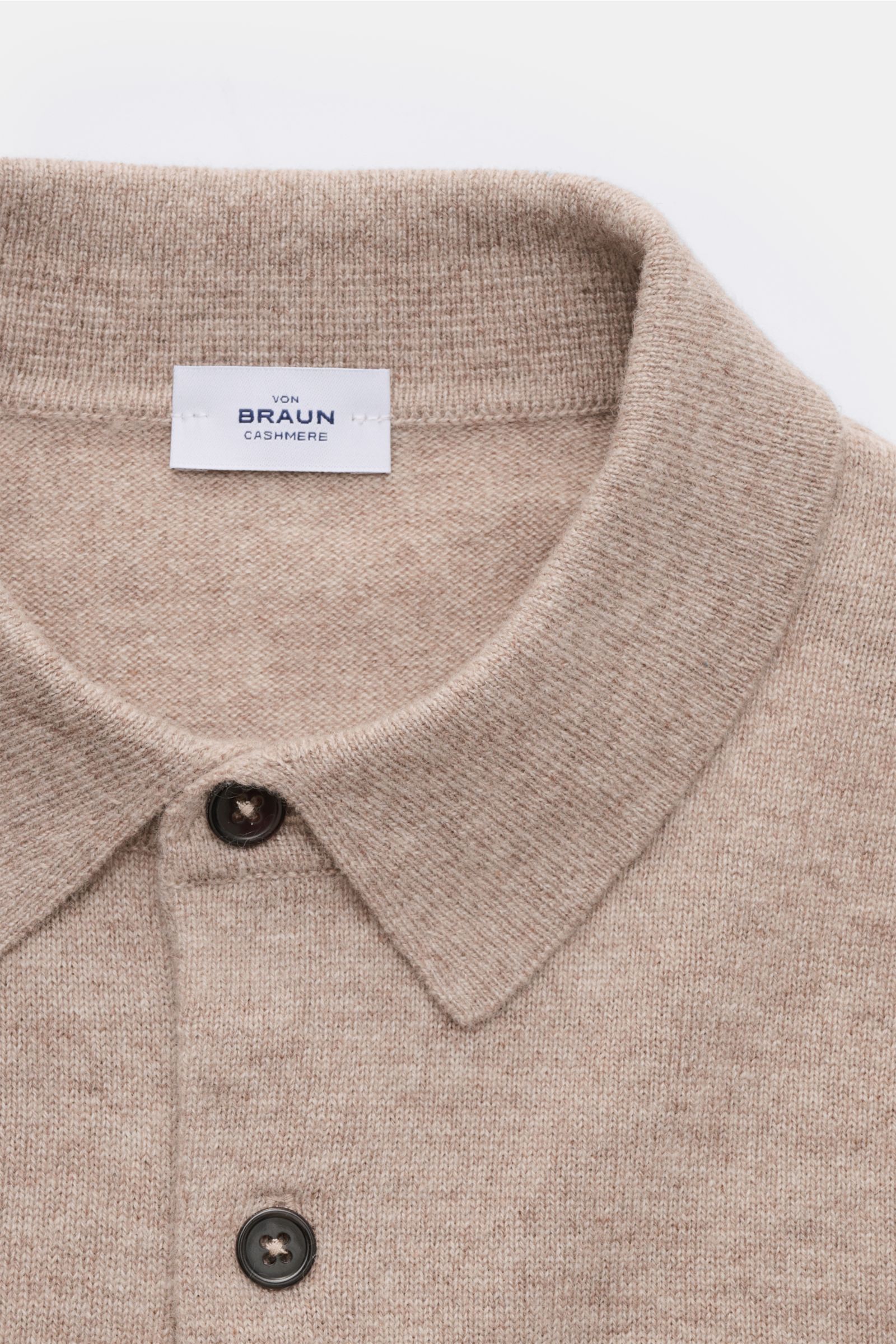 Nahaufnahme des von Braun Cashmere Strickpolo beige meliert aus weichem, reinem mongolischem Cashmere, Slim Fit, feines Strickbild, Polokragen mit Drei-Knopf-Leiste und elastischen Rippbündchen, frontal fotografiert.