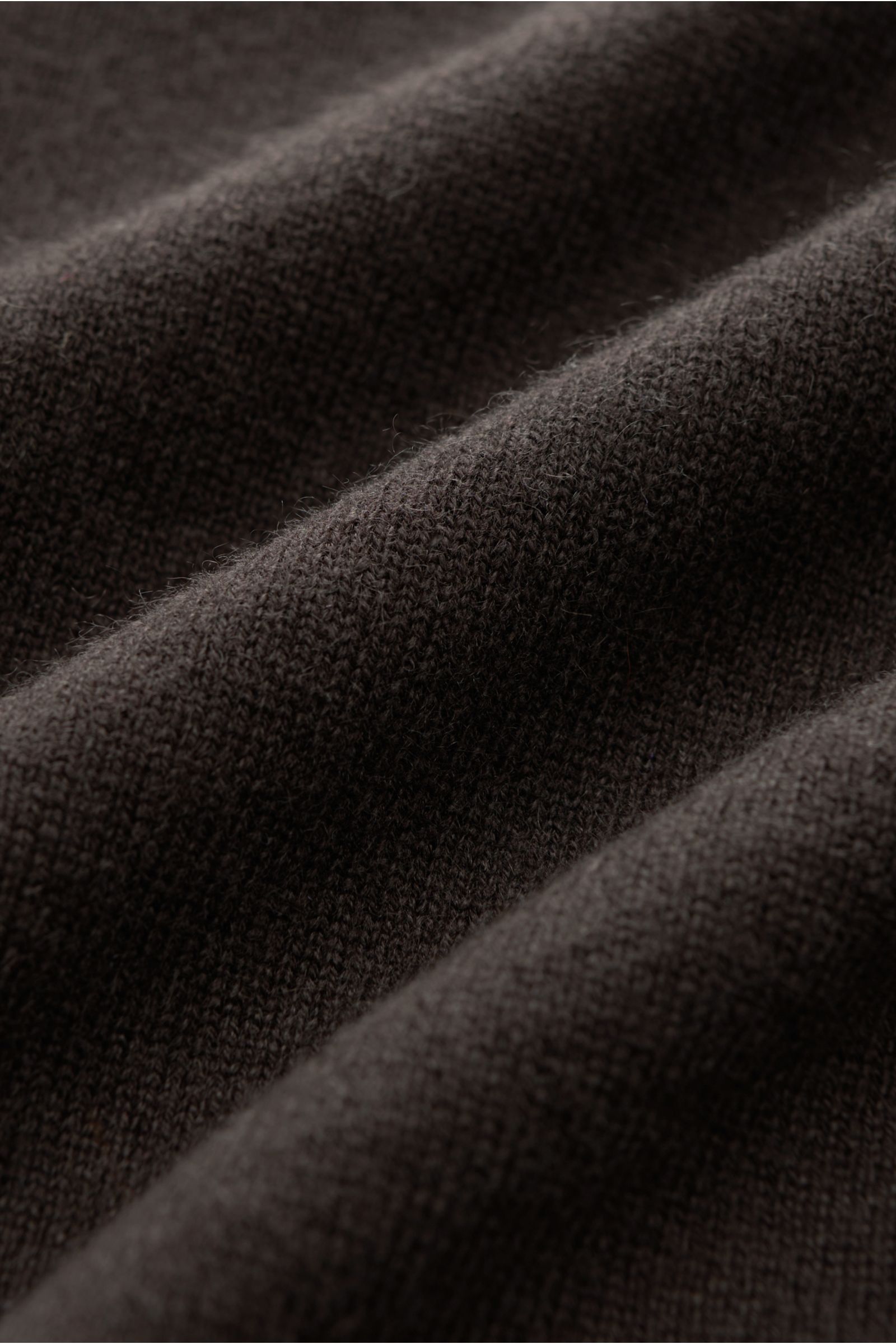 Close-up front view of the dark brown von Braun Cashmere knit polo fabric showing fine knit texture and soft feel, an elegant basic for the cold season: This VON BRAUN knit polo is an elegant alternative to a jumper – made from pure cashmere from Mongolia