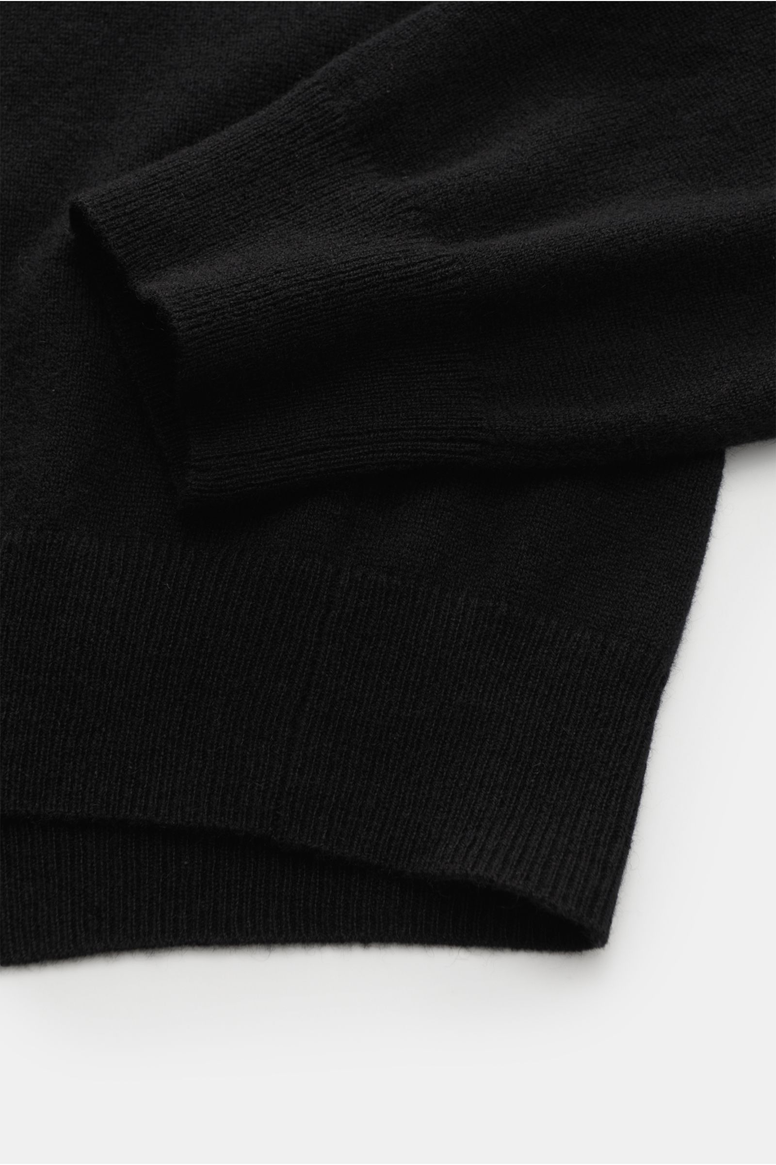 Close-up side view of von Braun Cashmere knit polo black sleeve and hem showing fine knit, elasticated ribbed bands, and soft texture.

Elegant basic for the cold season: This VON BRAUN knit polo is an elegant alternative to a jumper – made from pure c