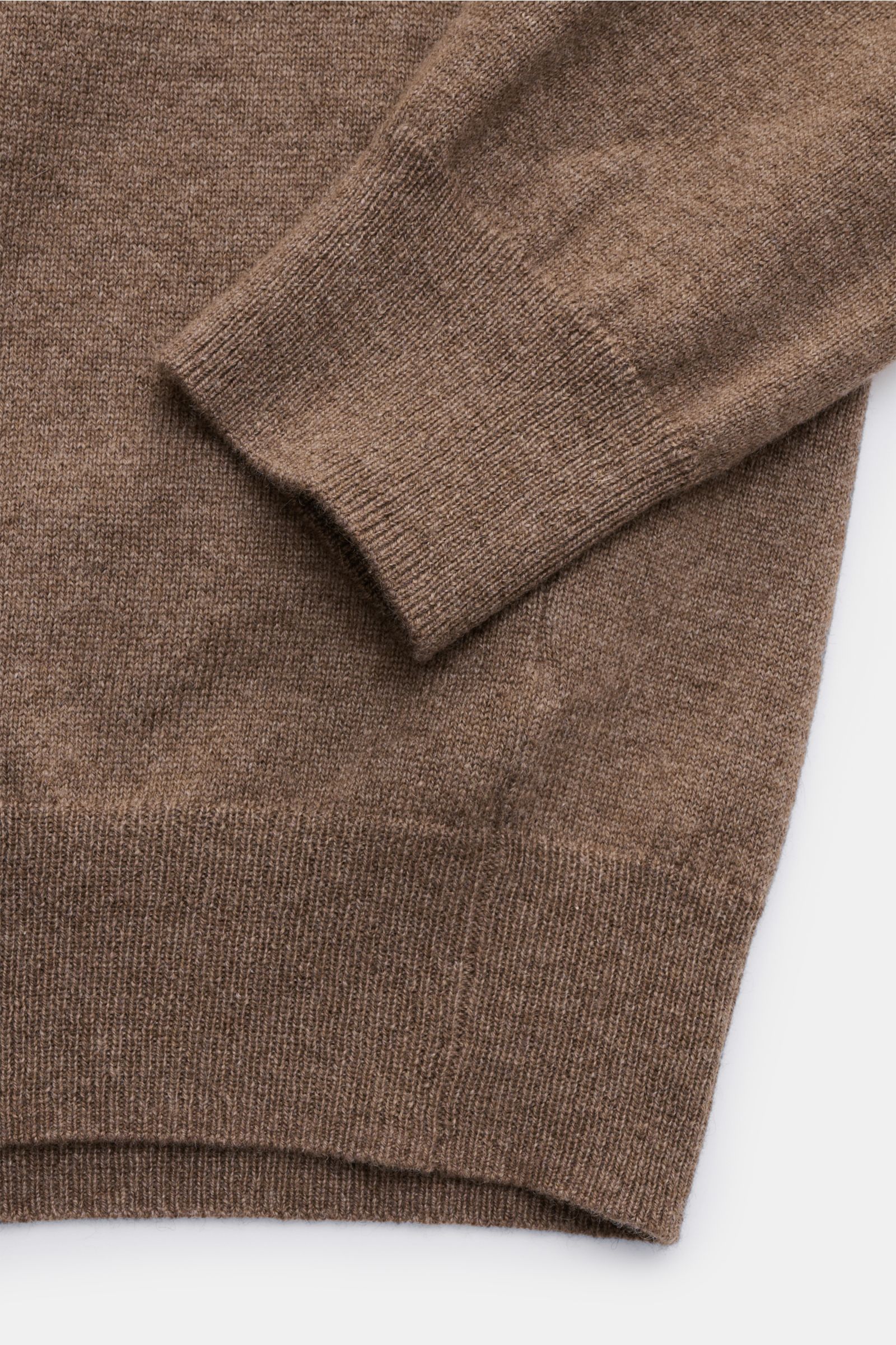Nahaufnahme des von Braun Cashmere Strickpolo braun, seitlich fotografiert, mit elastischem Rippbündchen und feinem Strickbild.