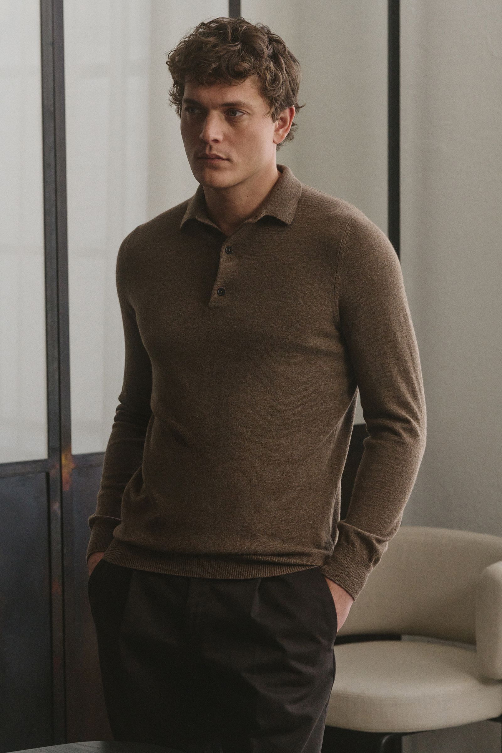 von Braun Cashmere Strickpolo braun in Slim Fit, seitliche Aufnahme eines Mannes mit drei-Knopf-Leiste, elastischen Rippbündchen, feinem Strickbild, weicher Cashmere-Qualität.
