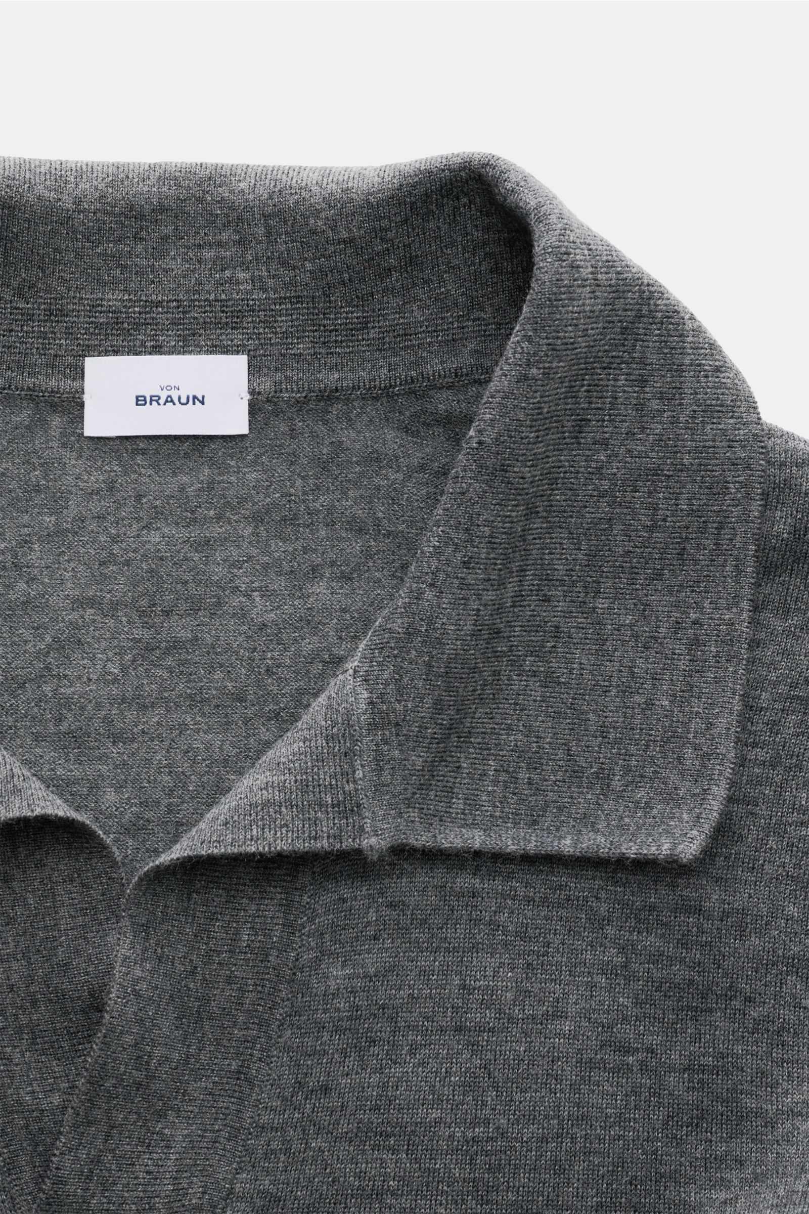 Nahaufnahme aus schräger Draufsicht des von Braun Merino Strickpolo anthrazit meliert mit offenem Polokragen, feinem Strickbild und weichem Griff.