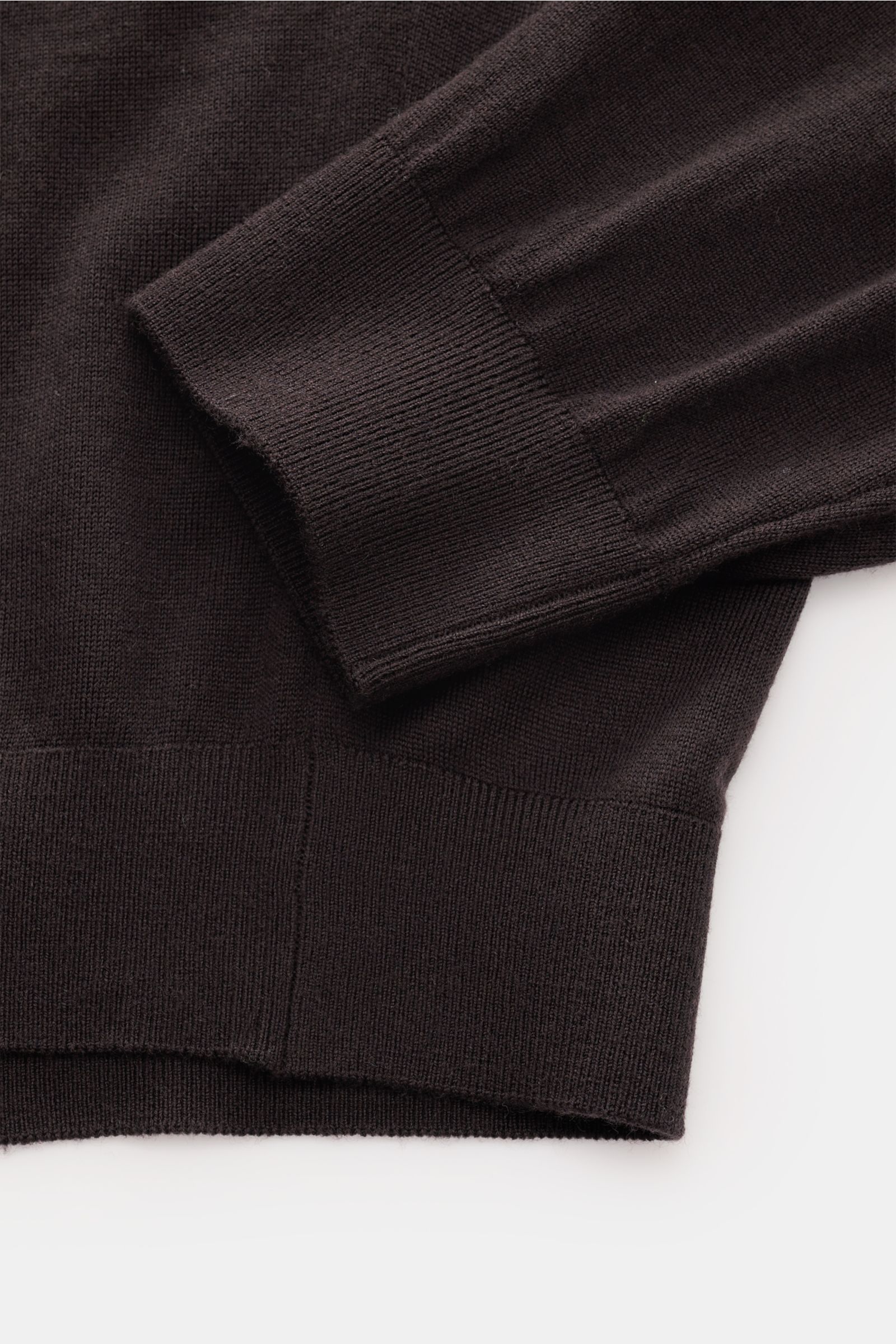 Close-up detail of the sleeve and hem of the von Braun Merino knit polo dark brown, showing fine knit texture and elasticated ribbed bands from a top-down perspective.

Description:  
An elegant basic for casual looks: This VON BRAUN knit polo with ope