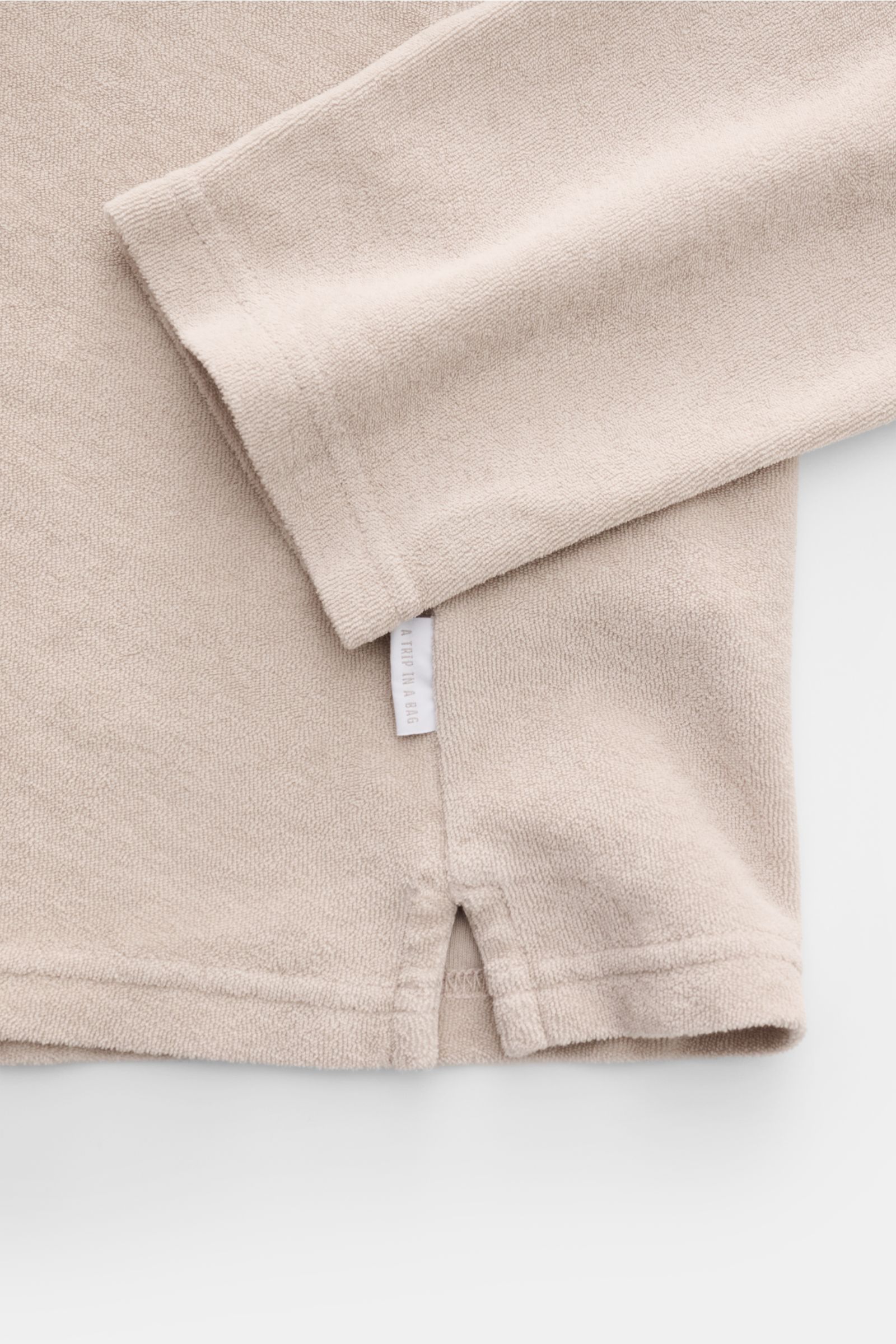 04651/ A trip in a bag Frottee Longsleeve-Poloshirt 'Terry Johnny' beige, Detailaufnahme unten mit kurzen Saumschlitzen und weichem Baumwoll-Frottee.