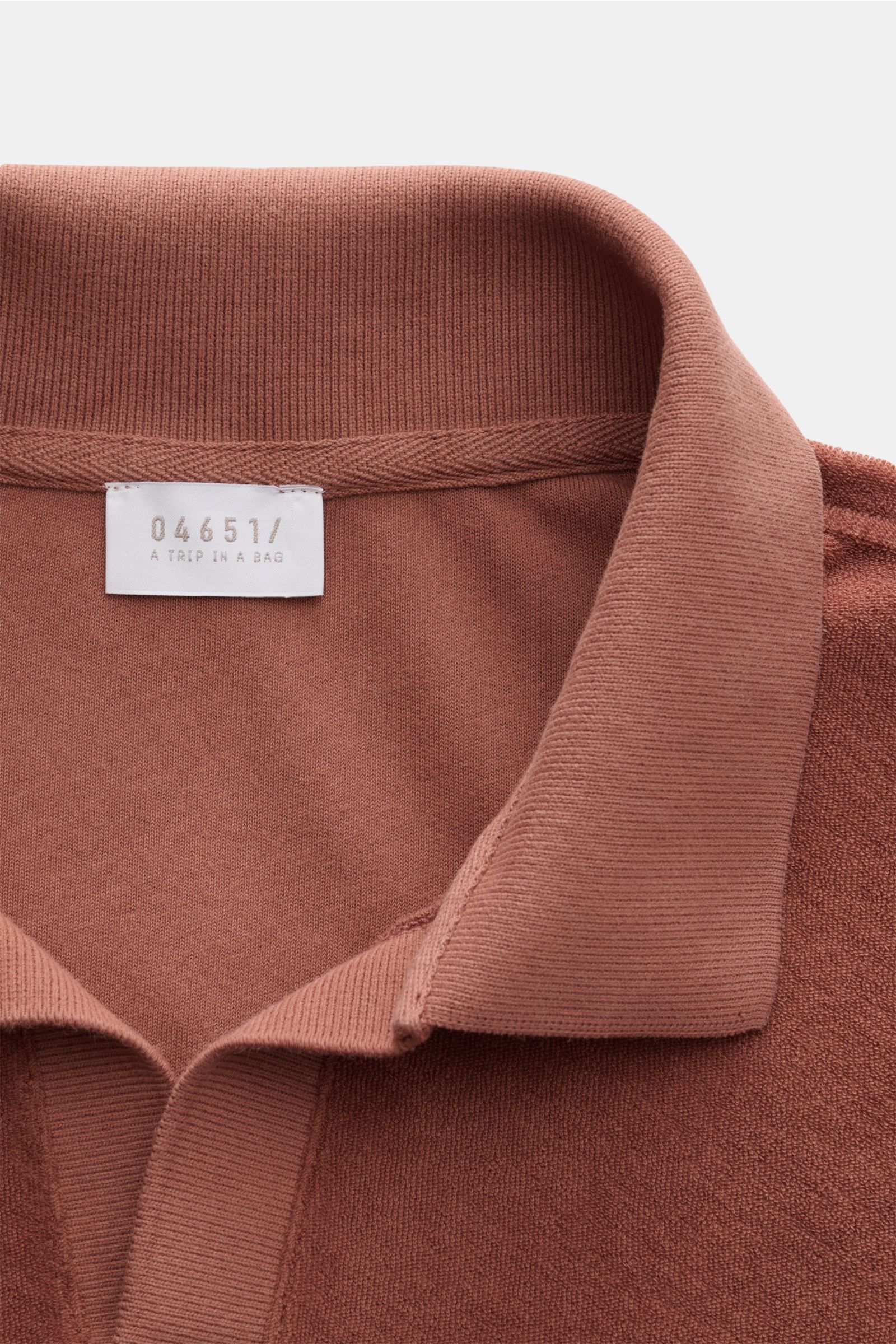 Nahaufnahme aus schräger Perspektive des Kragens und Labels vom 04651/ A trip in a bag Frottee Longsleeve-Poloshirt 'Terry Johnny' rostbraun, aus weichem Baumwoll-Frottee mit klassischem Polokragen und offener Kragenleiste, Regular Fit und kurzen Saumschl