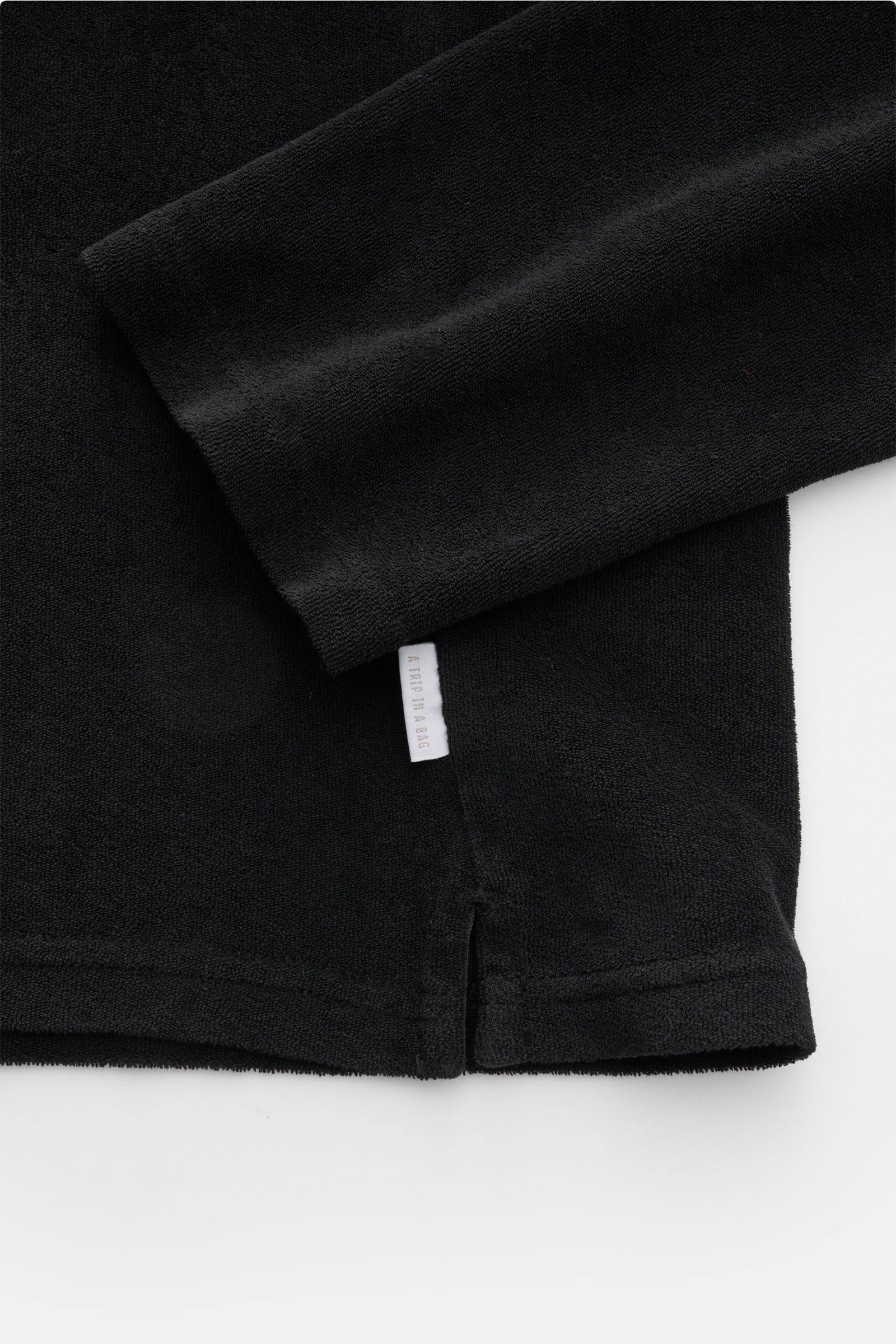 Schwarzes 04651/ A trip in a bag Frottee Longsleeve-Poloshirt 'Terry Johnny' aus reiner Baumwolle, weicher Griff, Regular Fit, kurze Saumschlitze, Detailfoto von Ärmel und Saum.