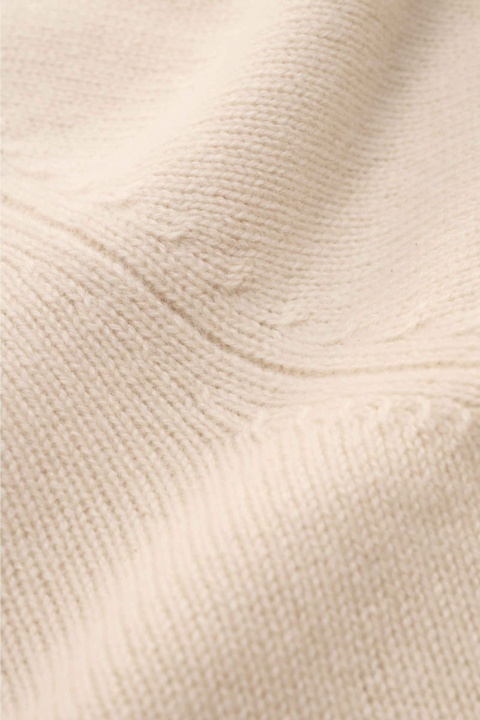 Nahaufnahme des Soft Goat Cashmere Strickpolo beige mit mittelfeinem Strickbild, offener Kragenleiste und weichem Griff.
