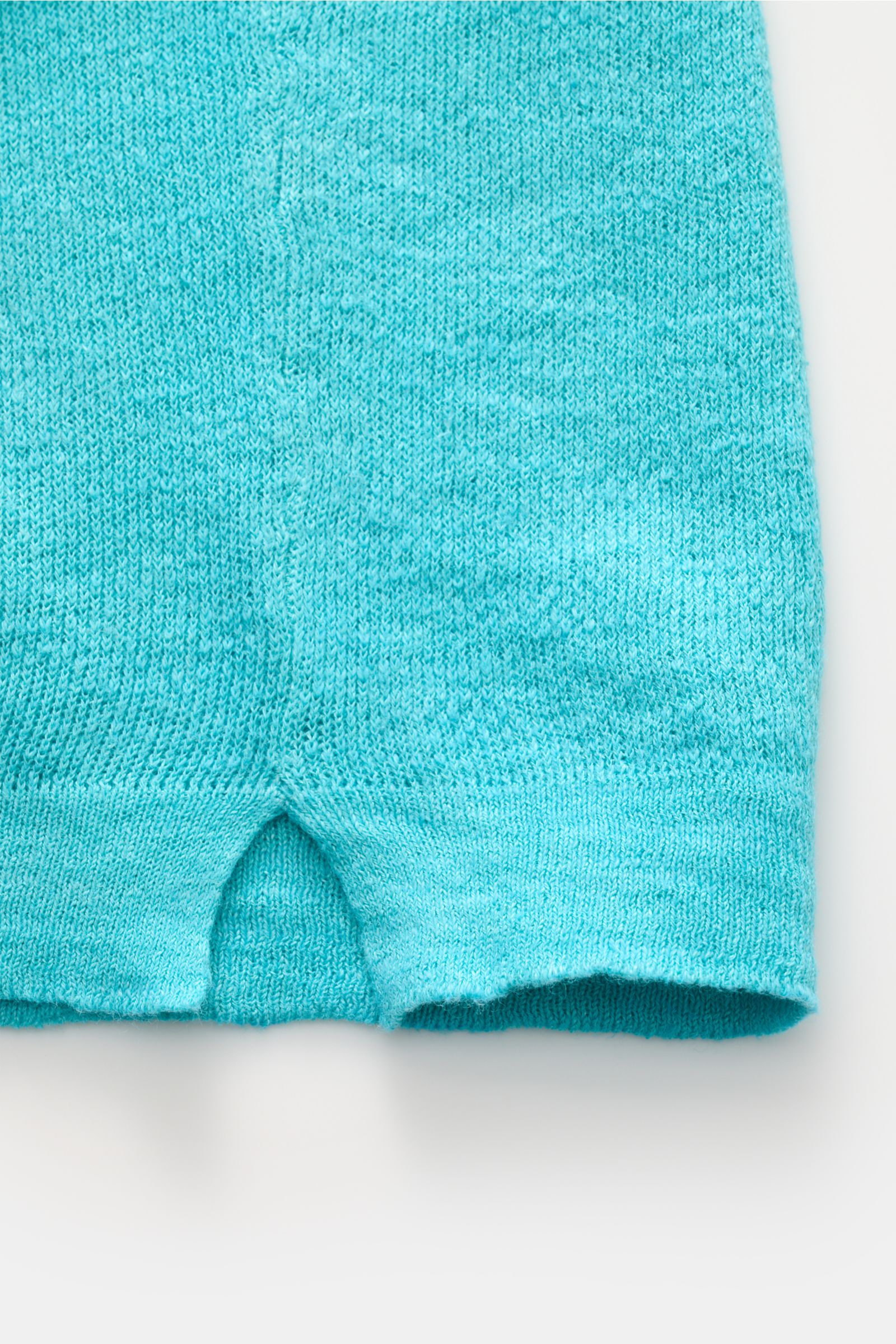 Detailaufnahme des türkisfarbenen 04651/ A trip in a bag Polo von unten, zeigt feine Strickstruktur und Saumgestaltung.