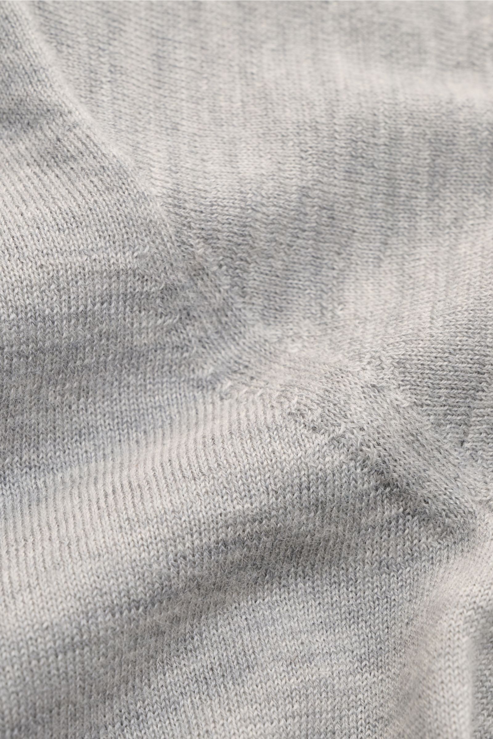 Lisa Yang Cashmere Kurzarm-Pullover 'Ancell' grau meliert aus reiner Cashmere-Faser, weicher Griff, feines Strickbild, Nahaufnahme von schräger Perspektive.