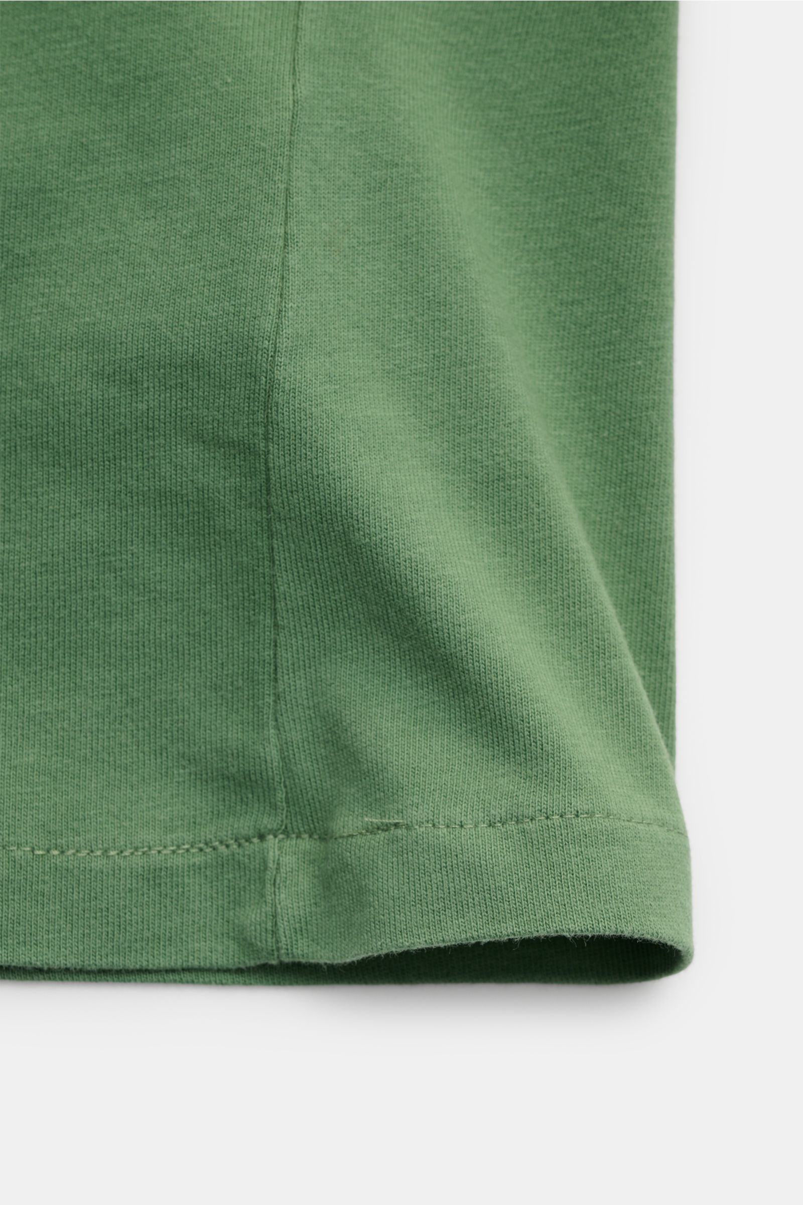 Close-up side view of the green Polo Ralph Lauren Rundhals-T-Shirt grün showing jersey fabric, seam, and hem details, featuring: 
- Jersey aus reiner Baumwolle
- weiche Qualität
- Regular Fit
- Rundhalsausschnitt
- labeltypisches Logo-Stitching auf der Br