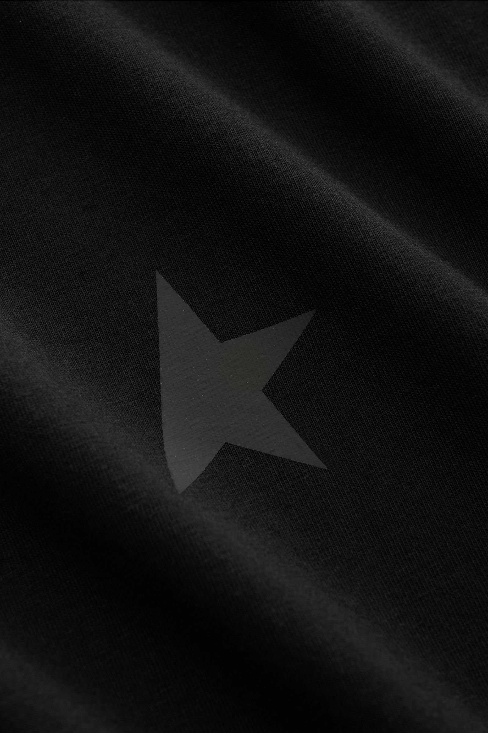 Golden Goose Crew neck T-shirt black shown up close from a front perspective, highlighting the subtle star logo on soft cotton jersey fabric. This T-shirt by GOLDEN GOOSE is exclusively Italian made and features the signature star logo on it’s cotton j