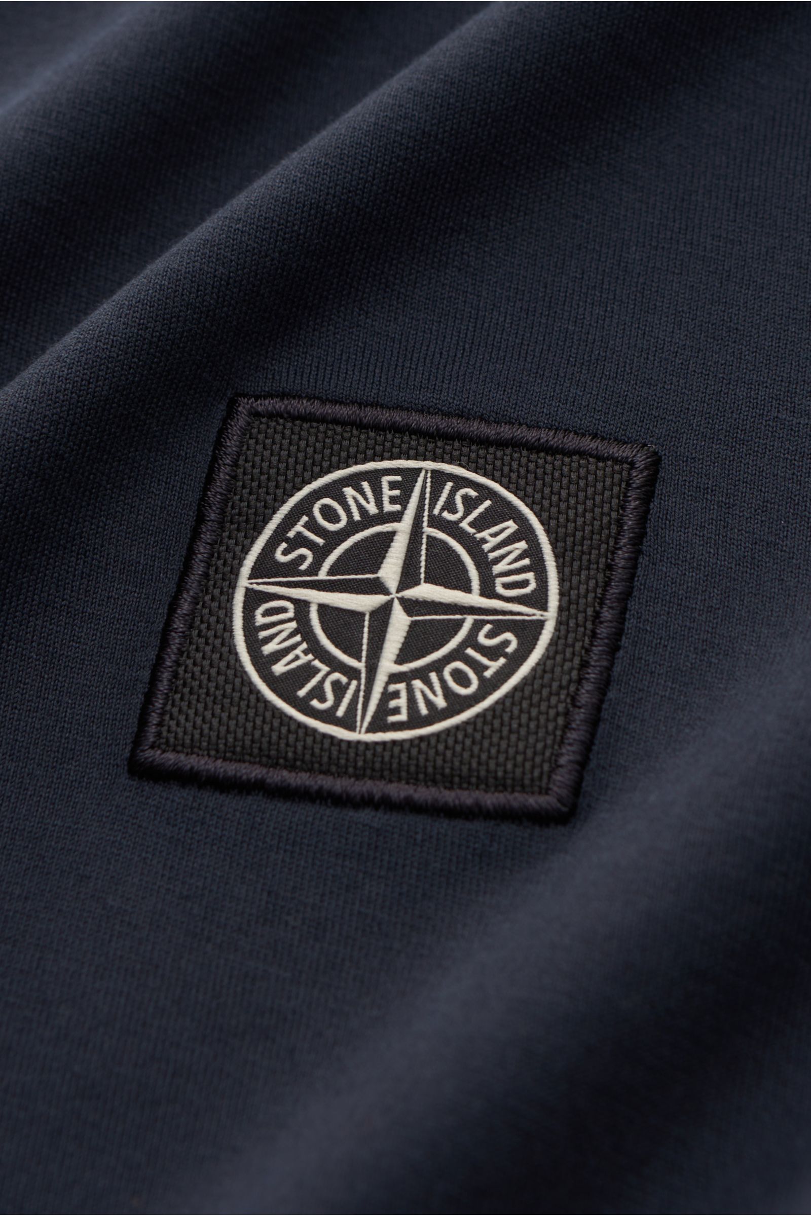 Stone Island Rundhals-T-Shirt navy als Nahaufnahme des Kompass-Logos auf garment dyed Baumwoll-Jersey mit weichem Griff.
