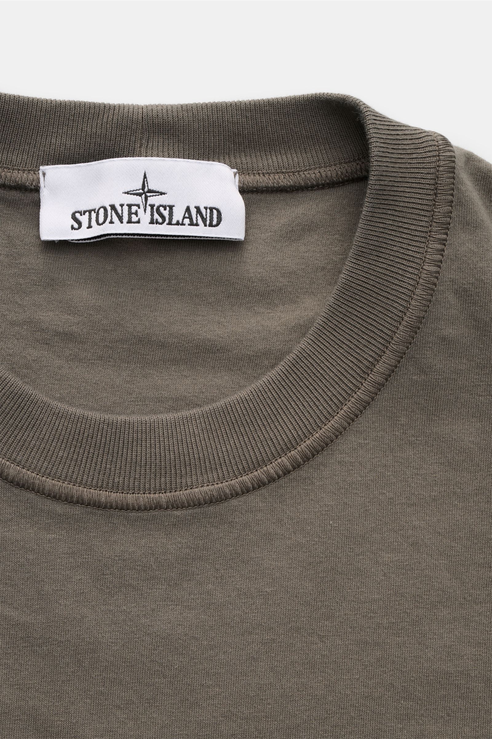 Stone Island Rundhals-T-Shirt graugrün aus Bio-Baumwolle, weicher Griff, Slim Fit, markante Overlock-Nähte, Rundhalsausschnitt, Weblabel, Nahaufnahme.