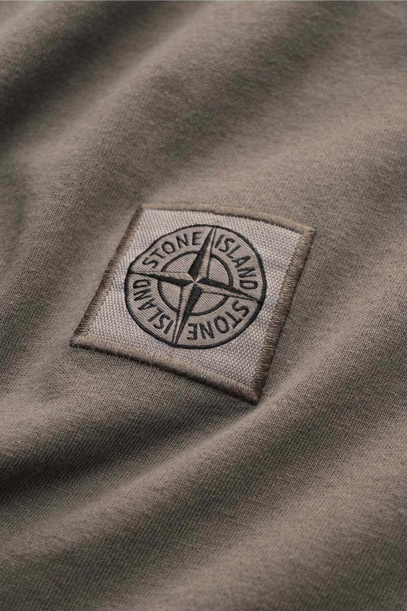 Close-up front view of the Stone Island Crew neck T-shirt grey-green showing the signature compass logo fabric label on soft organic cotton jersey.

STONE ISLAND delivers an essential basic for your casual wardrobe with this relaxed T-shirt made of org