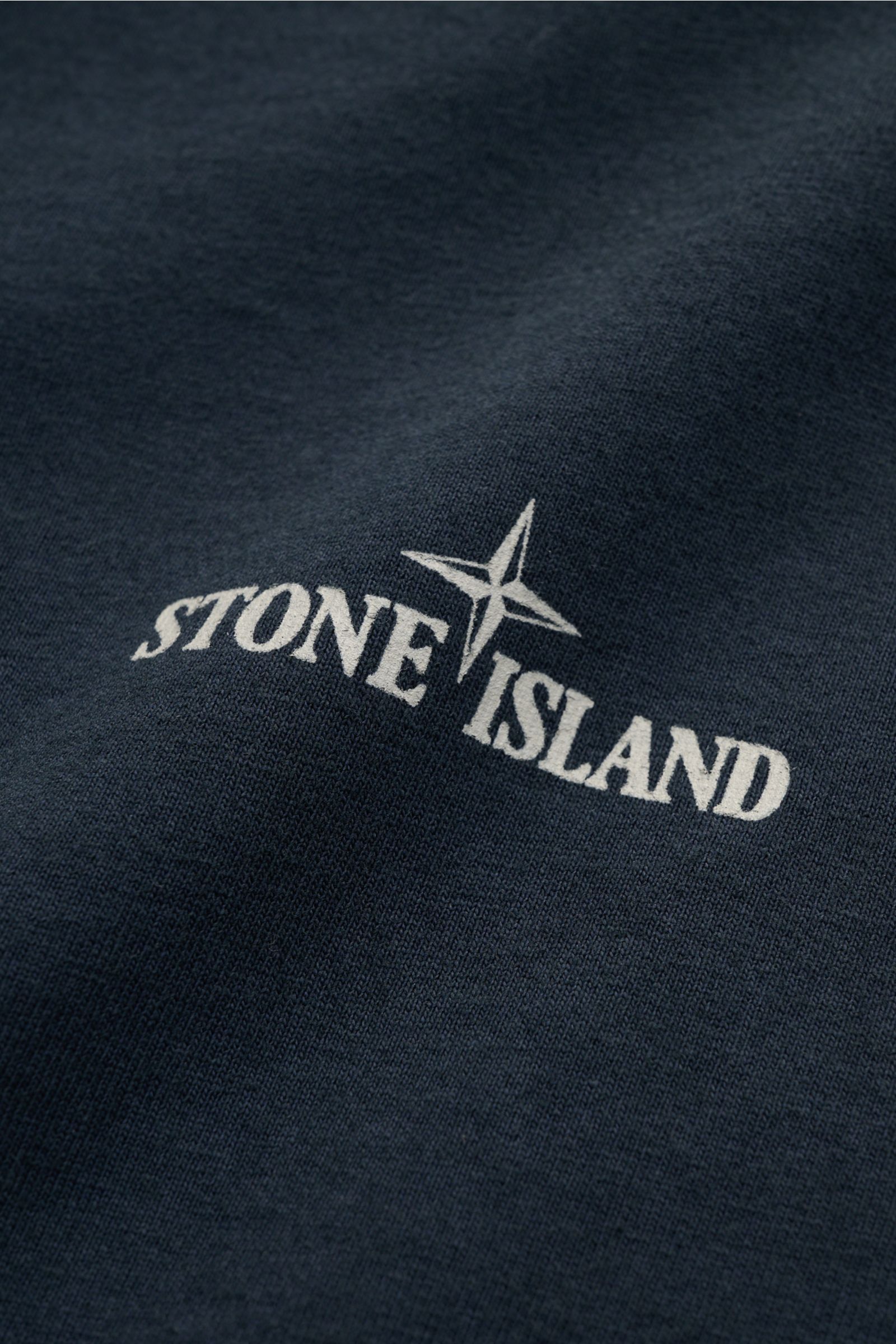 Stone Island Rundhals-T-Shirt 'Industrial Print' dark navy, Frontdetail mit STONE ISLAND-Print auf garment dyed Baumwolle, Nahaufnahme.