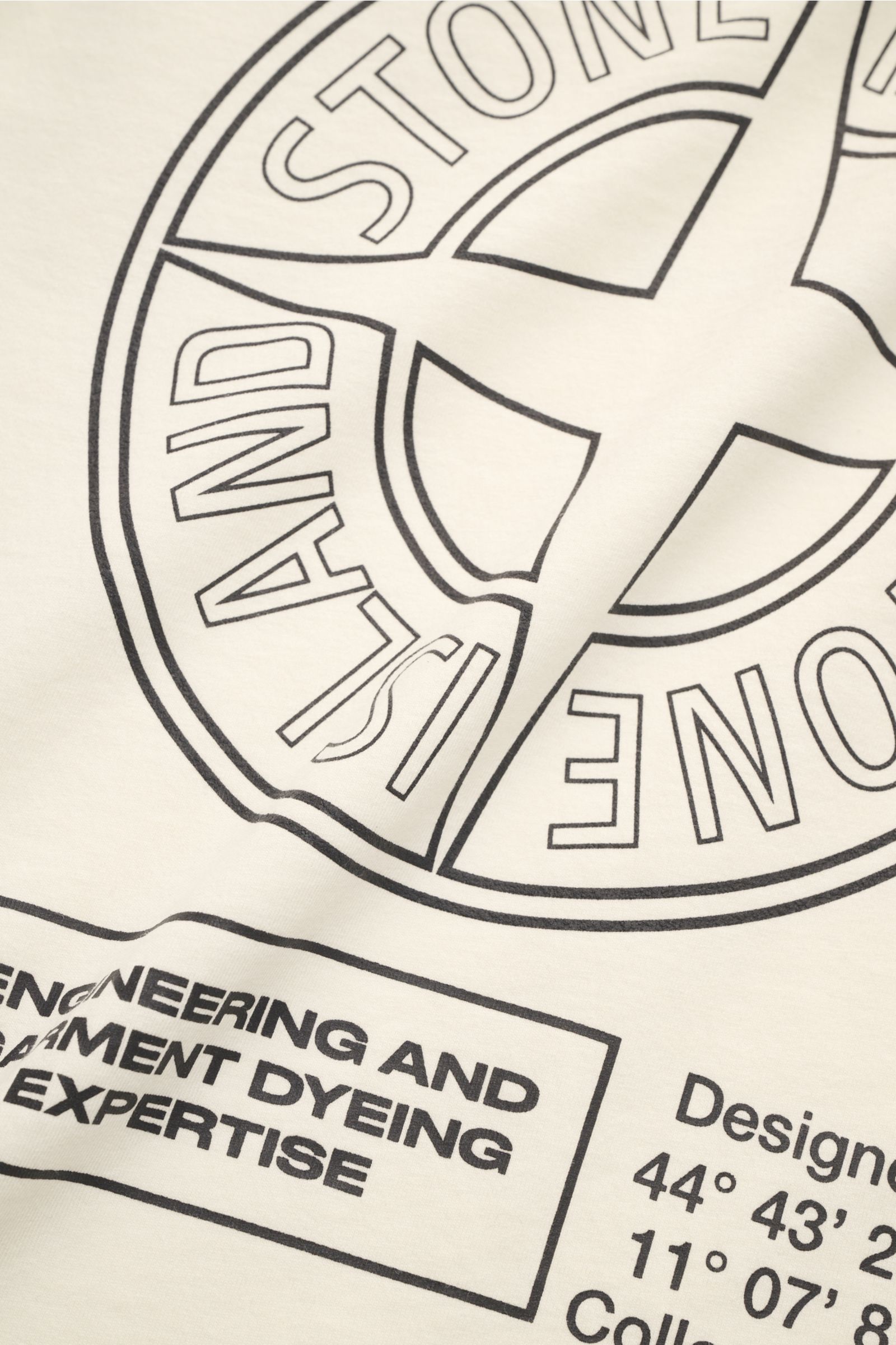 Stone Island Rundhals-T-Shirt 'Industrial Print' creme, Detailansicht des garment dyed Baumwolljerseys mit großem Kompass- und Logo-Print.