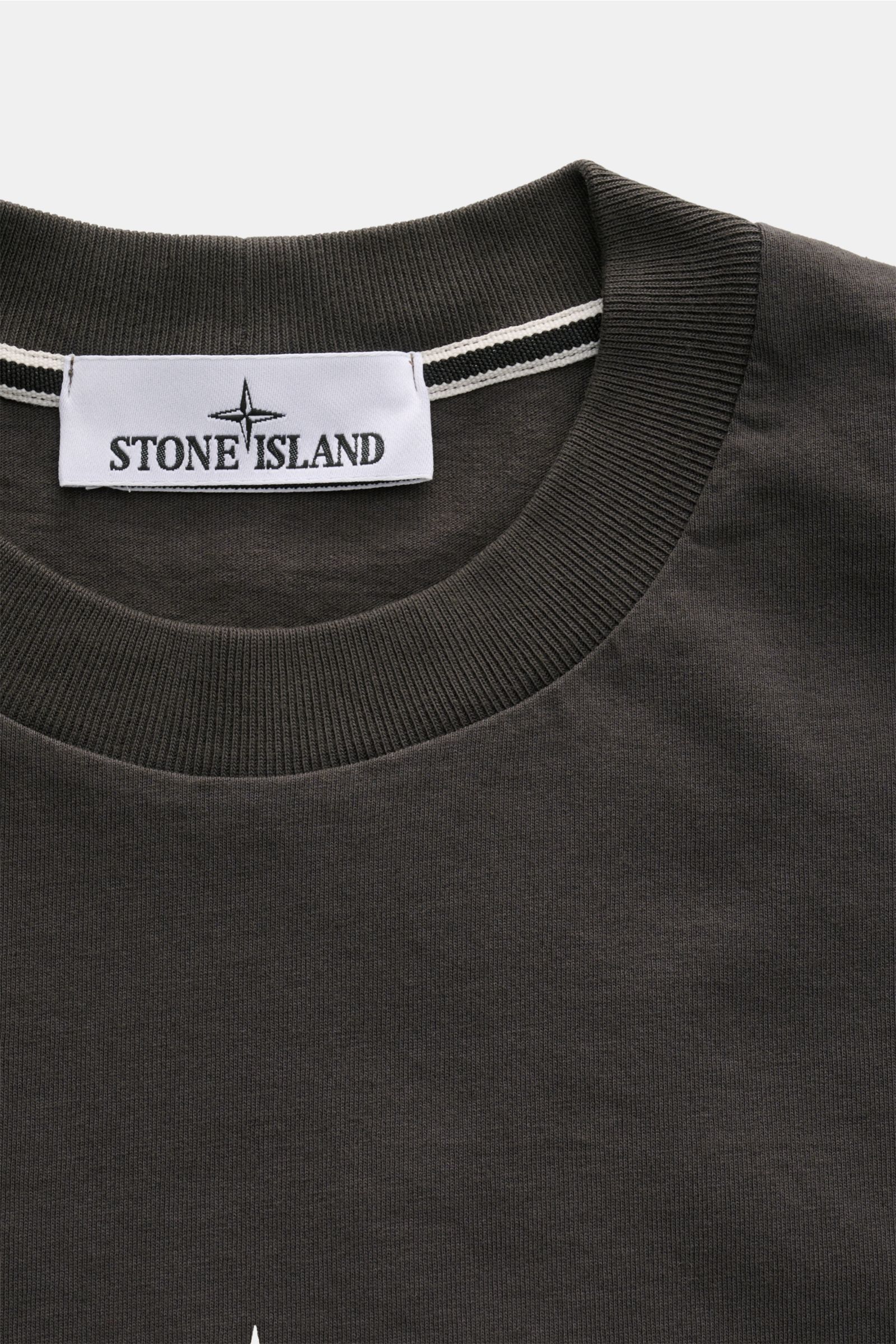 Stone Island Rundhals-T-Shirt 'Industrial Print' dunkelgrau shown in close-up from above, featuring ribbed round neckline and Stone Island label.

STONE ISLAND liefert mit diesem legeren T-Shirt aus Garment-dyed-Baumwolle mit charakteristischem Kompass