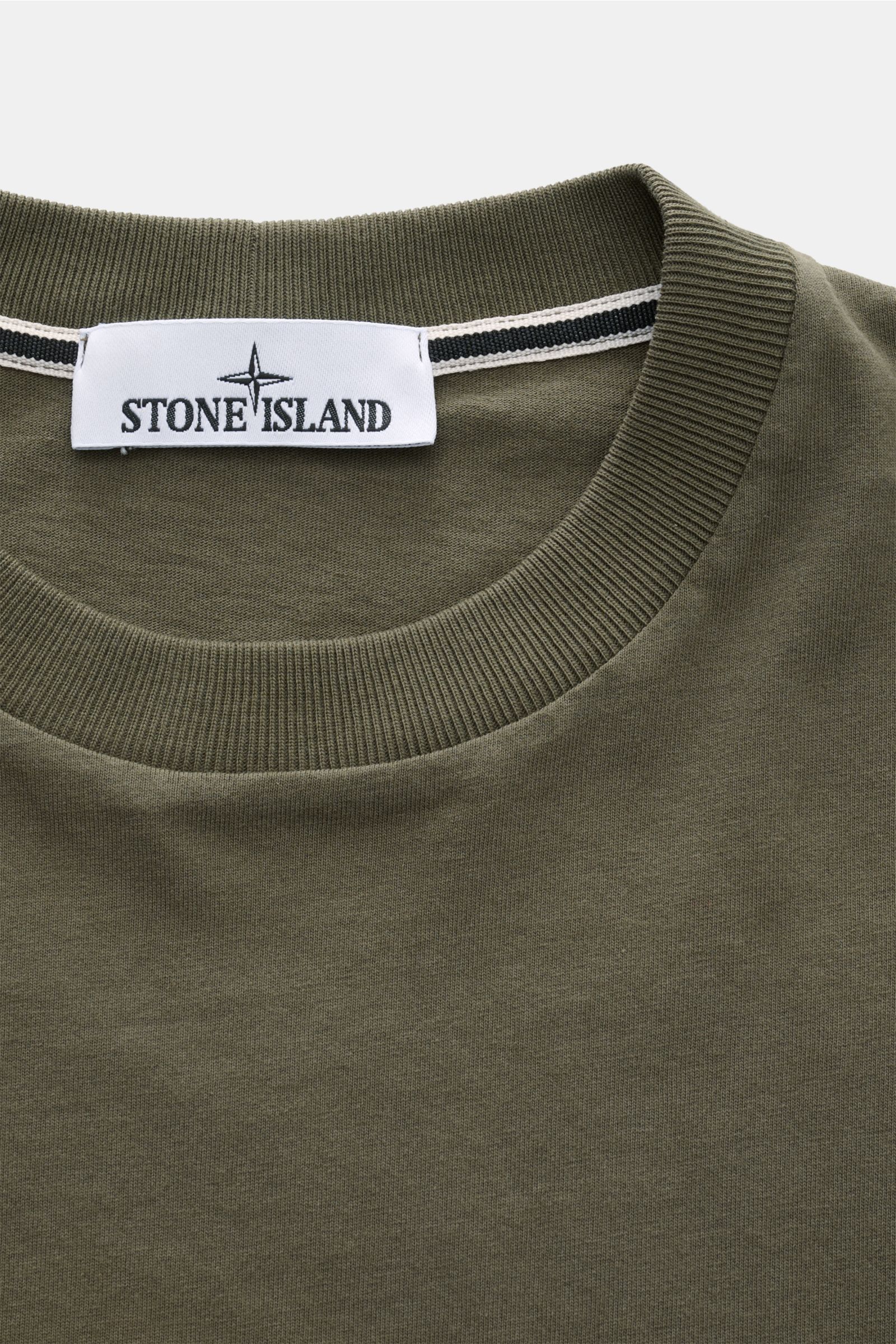 Close-up front view of the Stone Island Rundhals-T-Shirt oliv neckline, jersey aus reiner Baumwolle, schwere Qualität, leicht griffige Haptik, garment dyed, Regular Fit, Rundhalsausschnitt, print auf der Front, plakativer Print auf der Rückseite.