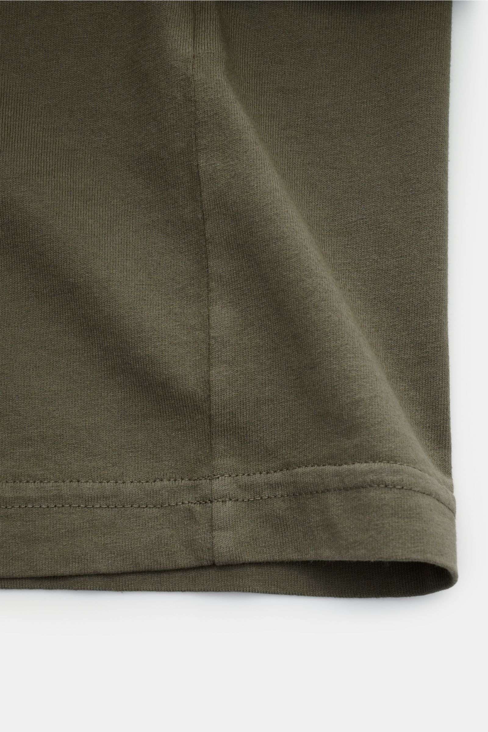Stone Island Rundhals-T-Shirt oliv shown in close-up from the side, highlighting the hem and stitching. Jersey aus reiner Baumwolle, schwere Qualität, leicht griffige Haptik, garment dyed, Regular Fit, Rundhalsausschnitt, Print auf der Front, plakativer P