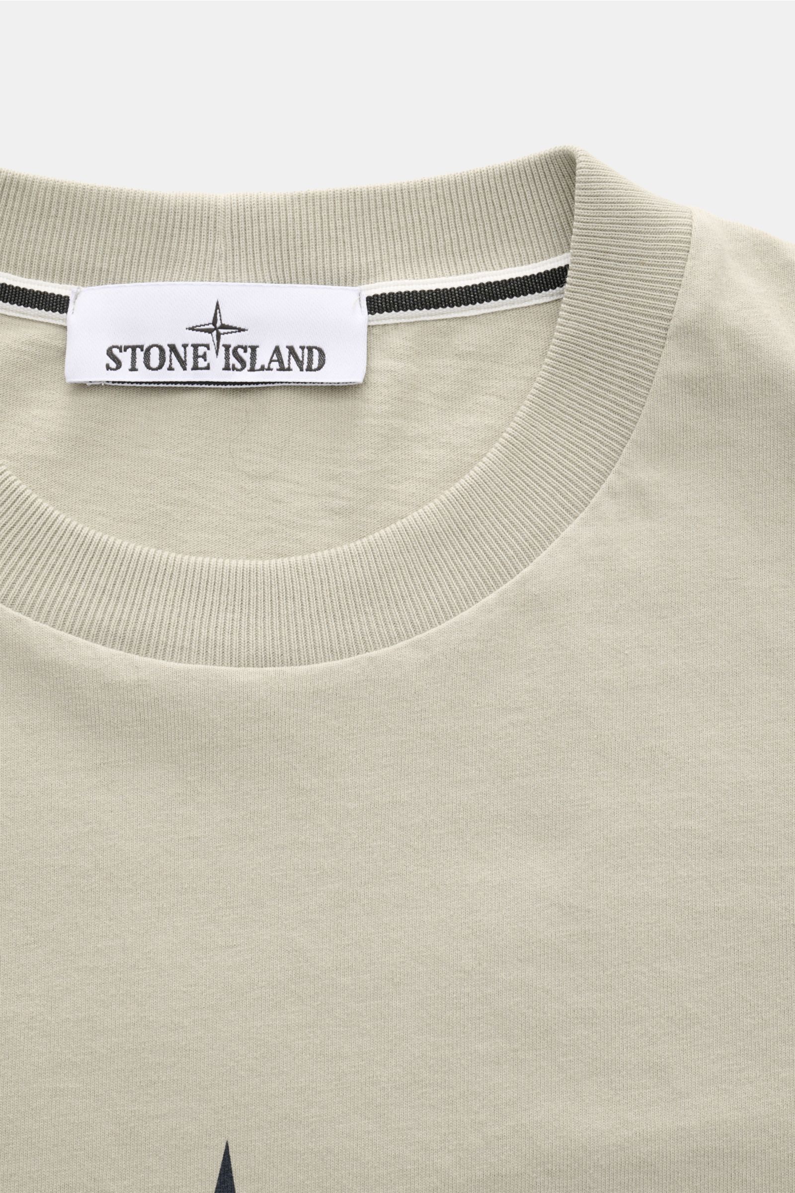 Stone Island Rundhals-T-Shirt sand close-up front view of ribbed crew neckline, jersey aus reiner Baumwolle, schwere Qualität, leicht griffige Haptik, garment dyed, Regular Fit, print auf der Front, plakativer Print auf der Rückseite.
