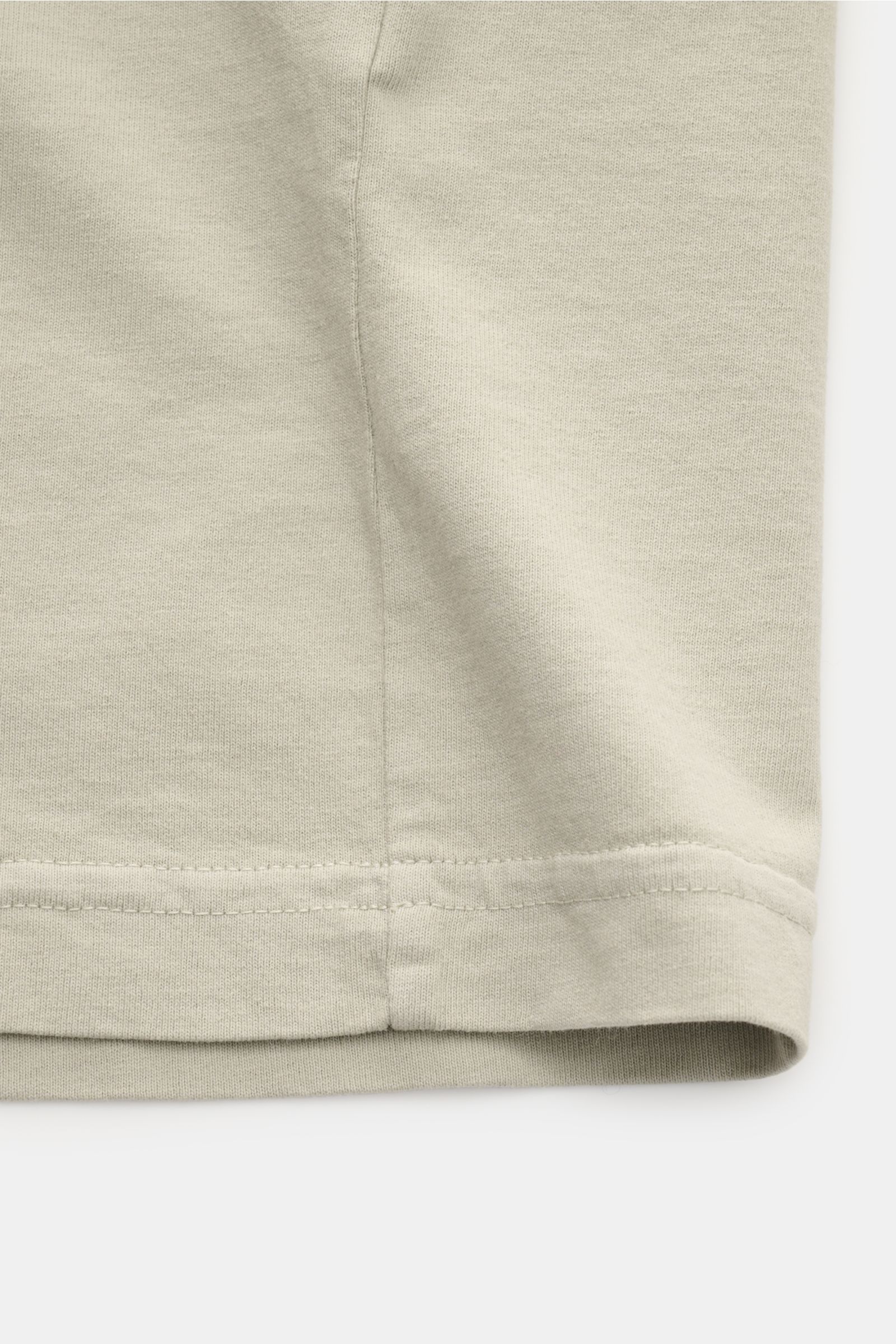 Close-up view of the hem and side seam of the Stone Island Rundhals-T-Shirt sand, made of jersey aus reiner Baumwolle, schwere Qualität, leicht griffige Haptik, garment dyed, Regular Fit, with Rundhalsausschnitt, print auf der Front, and plakativer Print 