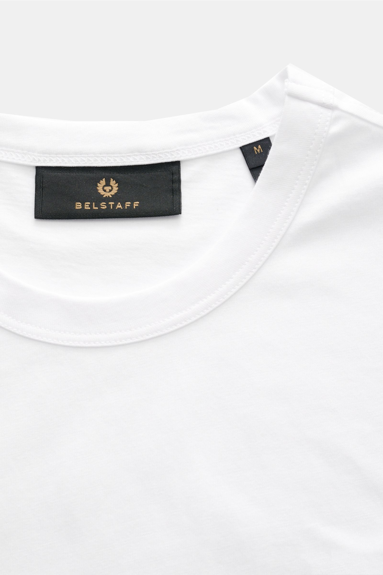 Close-up image of the Belstaff Rundhals-T-Shirt weiß showing the neckline and black BELSTAFF web label from a top-front perspective.

Description: Dieses T-Shirt von BELSTAFF, gefertigt aus leichtem Baumwoll-Jersey und veredelt mit einem dezenten Webla