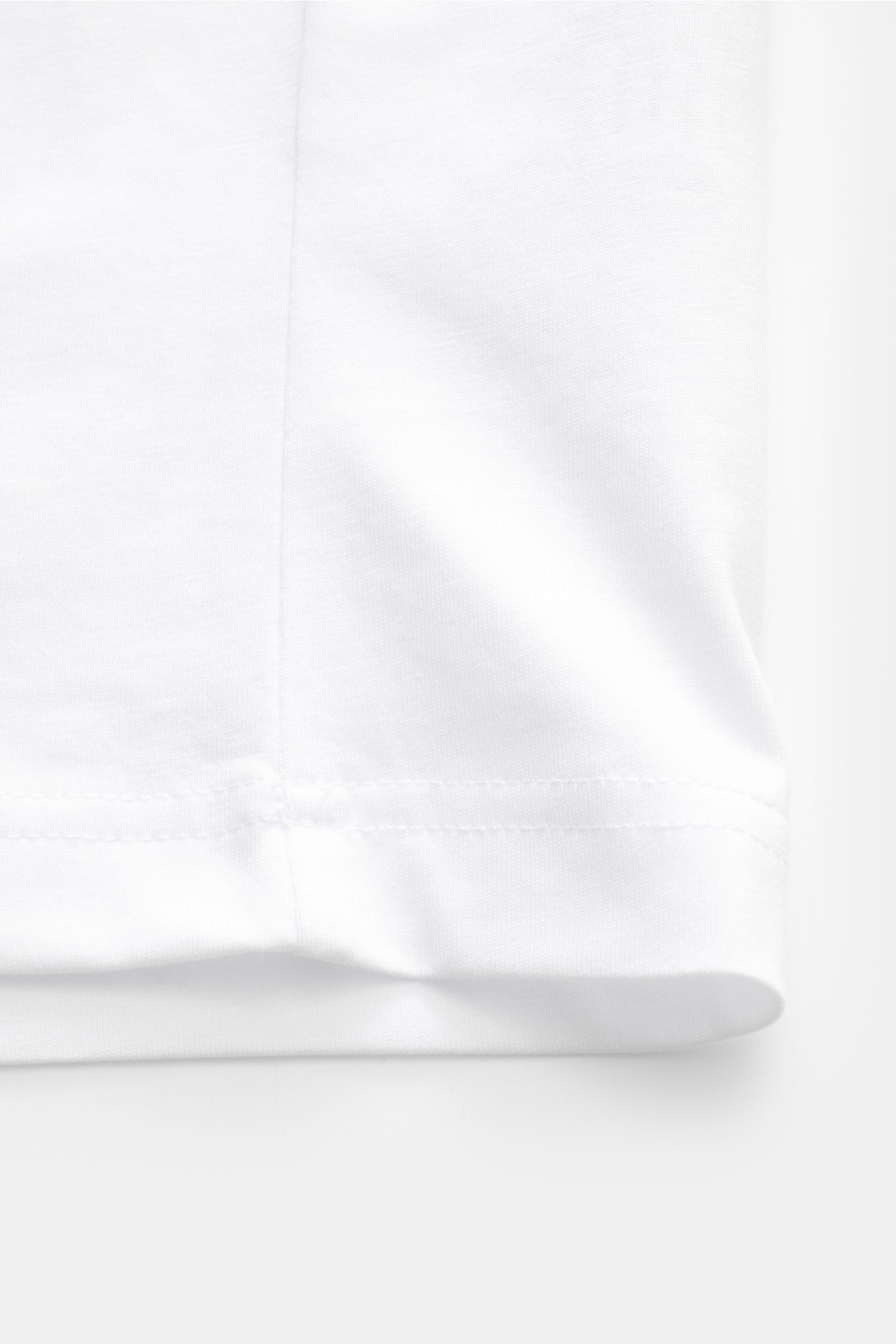 Alt tag (124 characters): Close-up of the hem of the Belstaff Rundhals-T-Shirt weiß, showing white cotton jersey fabric and stitching from a side view.

Description:  
Dieses T-Shirt von BELSTAFF, gefertigt aus leichtem Baumwoll-Jersey und veredelt mit